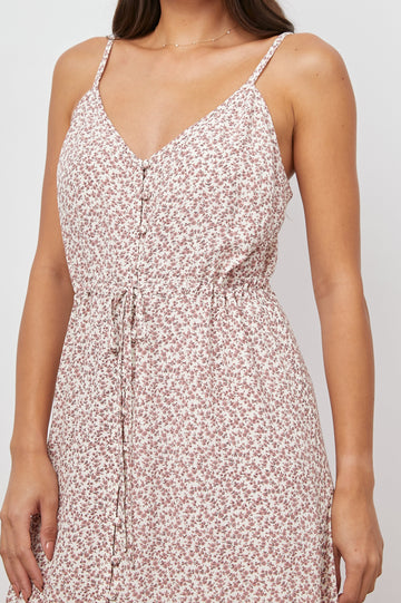 Frida Midi Dress with a Deep V Neck, Adjustable Spaghetti Straps, a Ruffled Hem, Drawstring Waist Ties and Buttons Down the Front in Garden Party Colorway, Pink Flowers on White - Front View Featured on Model