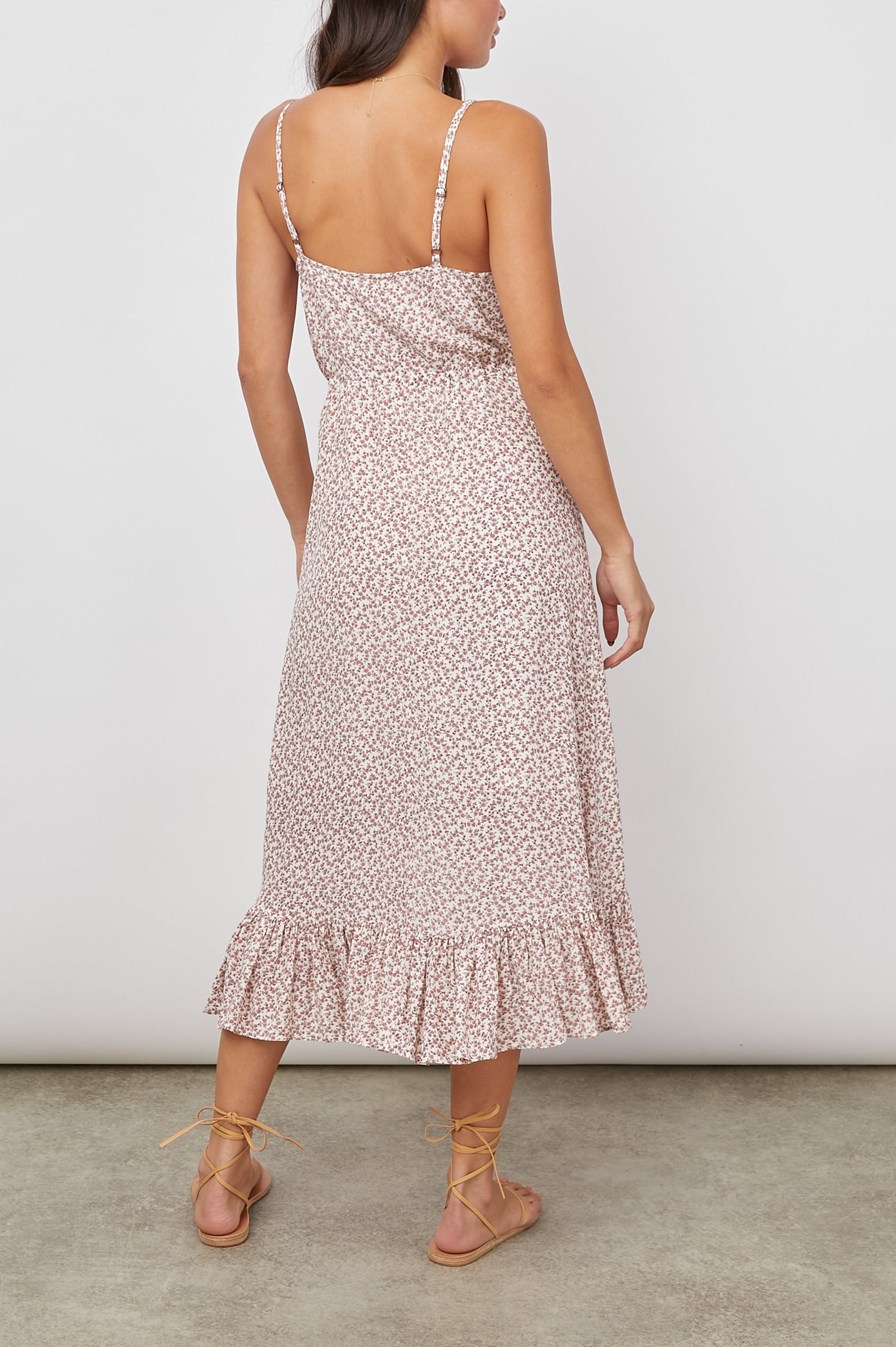 Frida Midi Dress with a Deep V Neck, Adjustable Spaghetti Straps, a Ruffled Hem, Drawstring Waist Ties and Buttons Down the Front in Garden Party Colorway, Pink Flowers on White - Back Full Body View Featured on Model