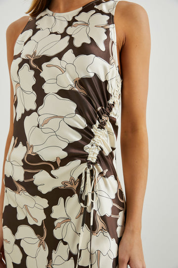 Gabriella Sleeveless Midi Dress with a Crew Neck, a Left Thigh Side Slit, a Ruched Drawstring on the Left Side and a Keyhole Button Closure at the Back in Mocha Floral Colorway, Flowers in Cream and Tan on Mocha - Front View Featured on Model 