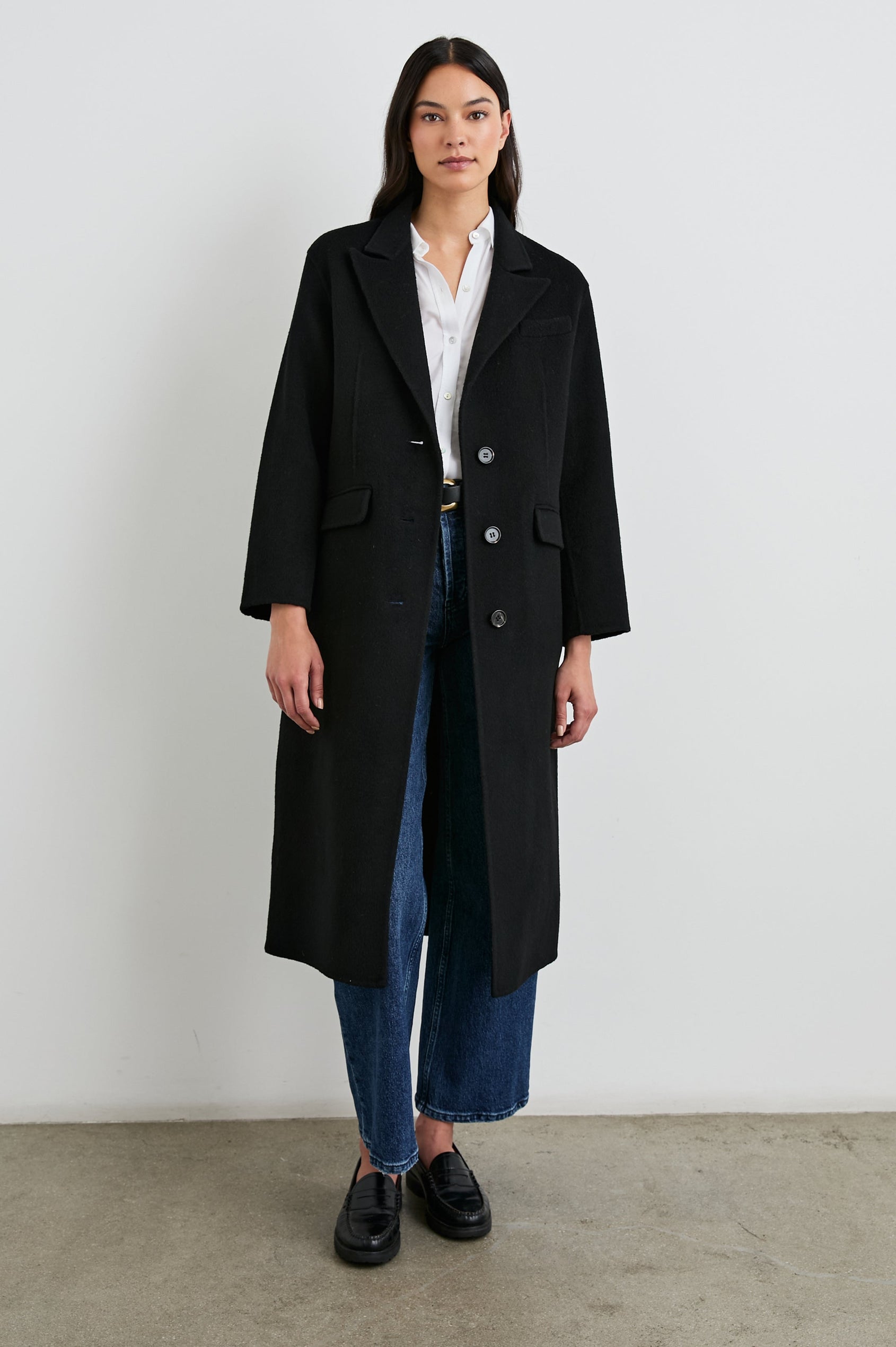 Gallery Below-the-Knee Coat with Three-Button Closure, Notched Lapels, and Two Front Flap Pockets in Black Colorway - Front Full Body View Featured on Model