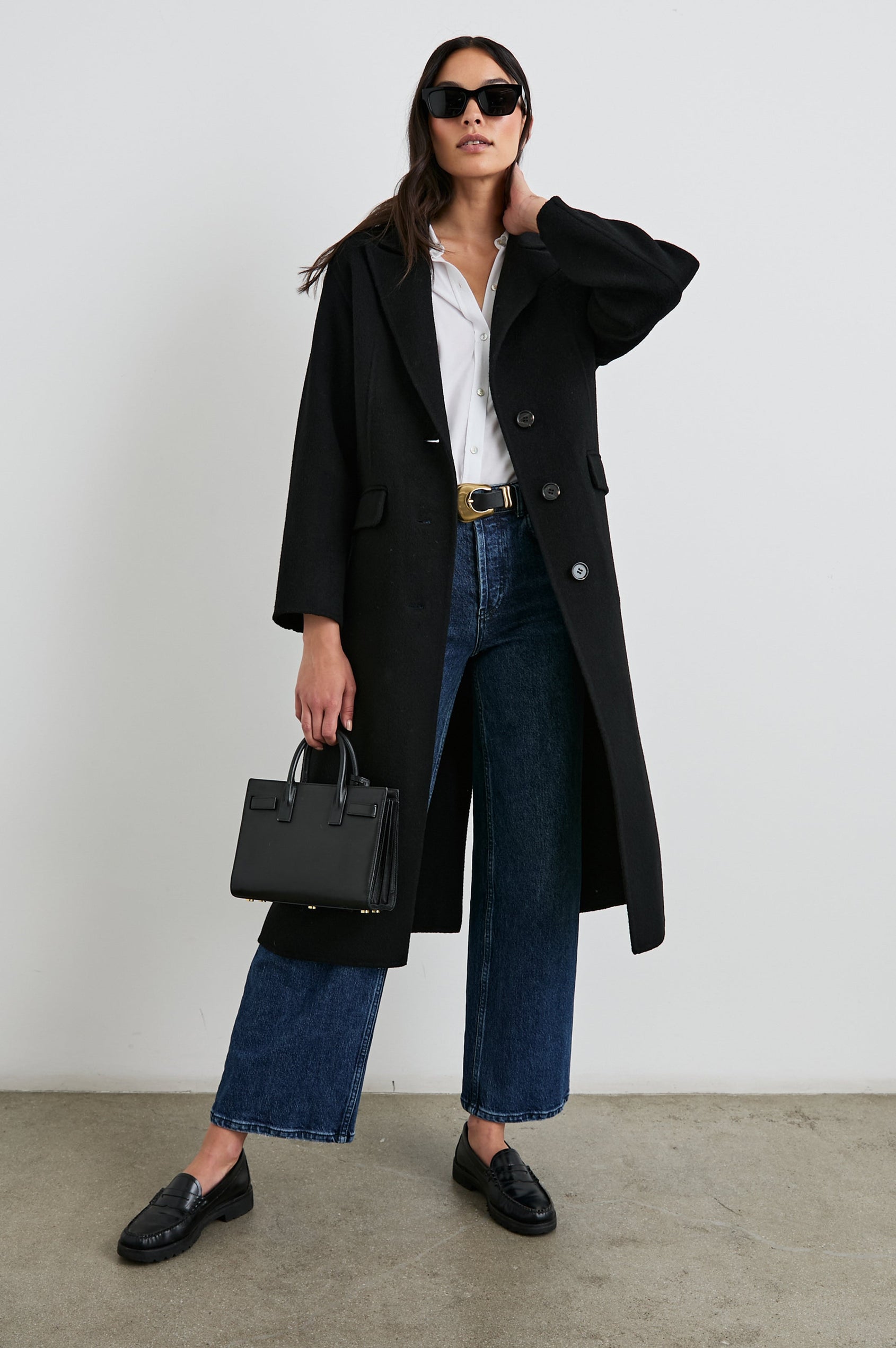 Gallery Below-the-Knee Coat with Three-Button Closure, Notched Lapels, and Two Front Flap Pockets in Black Colorway - Front Full Body View Featured on Model