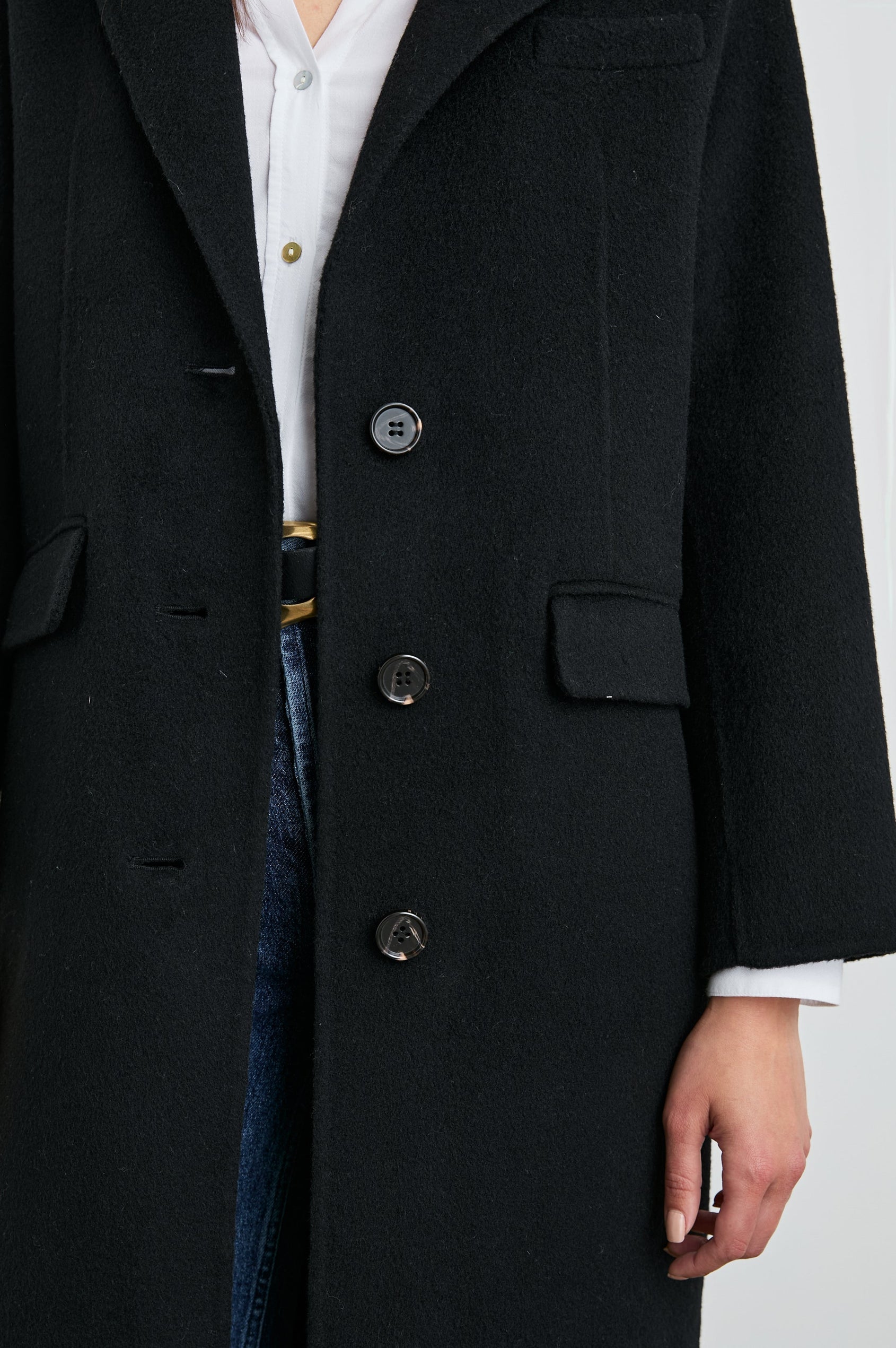 Gallery Below-the-Knee Coat with Three-Button Closure, Notched Lapels, and Two Front Flap Pockets in Black Colorway - Front View Featured on Model