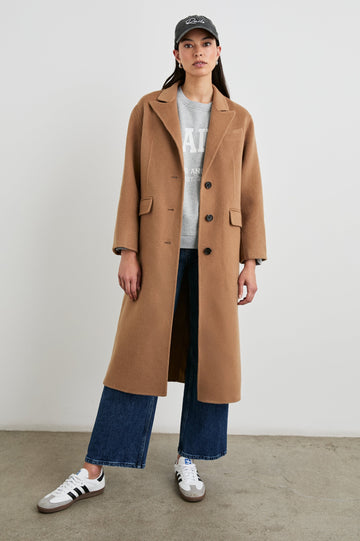 Gallery Below-the-Knee Coat with Three-Button Closure, Notched Lapels, and Two Front Flap Pockets in Camel Colorway - Front Full Body View Featured on Model