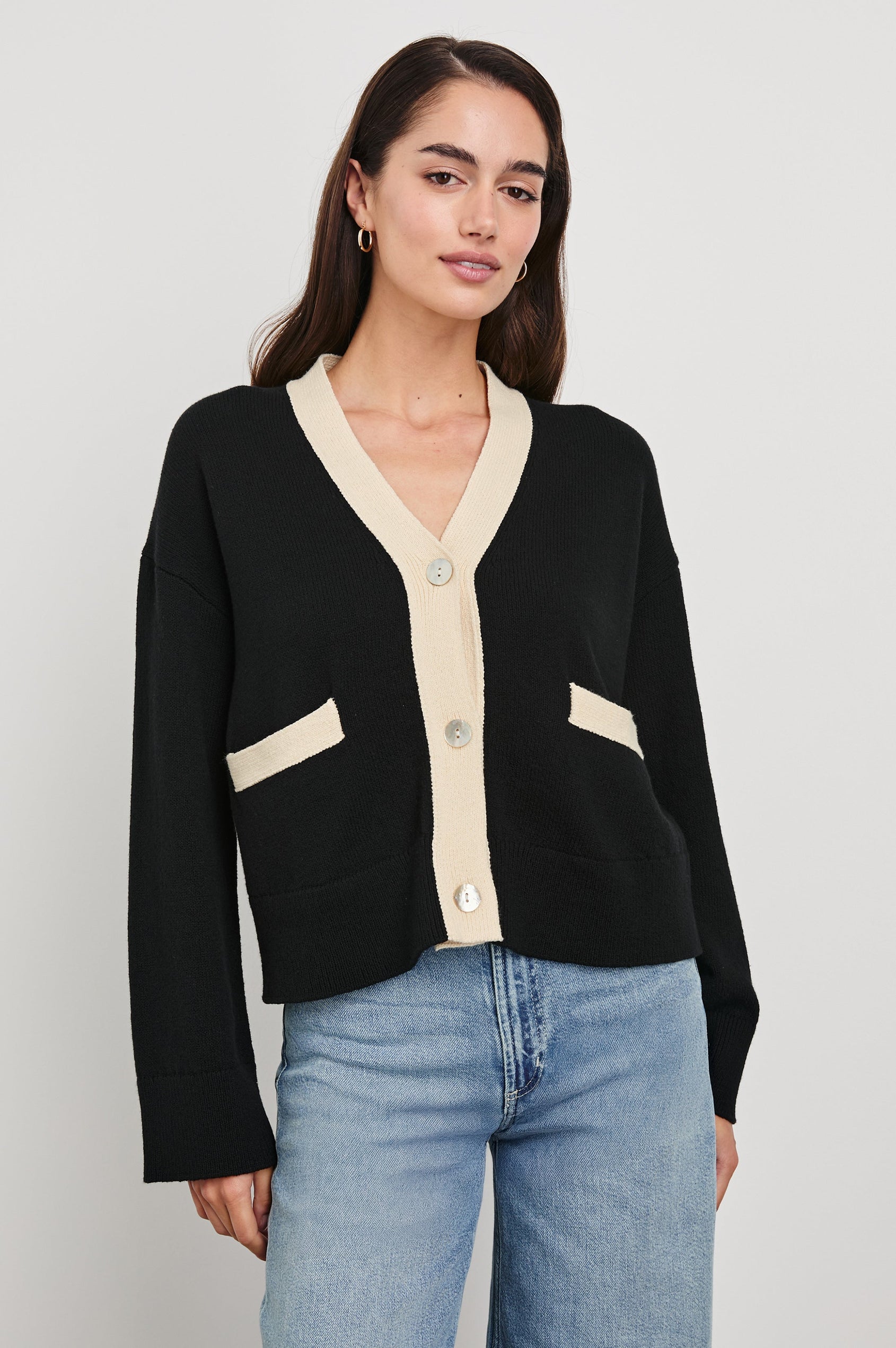 Geneva Long-Sleeve Cardigan with Two Front Patch Pockets and Button Closure in Black Ivory Colorway, with Ivory neckline, closure and pocket openings on Black - Front View Featured on Model