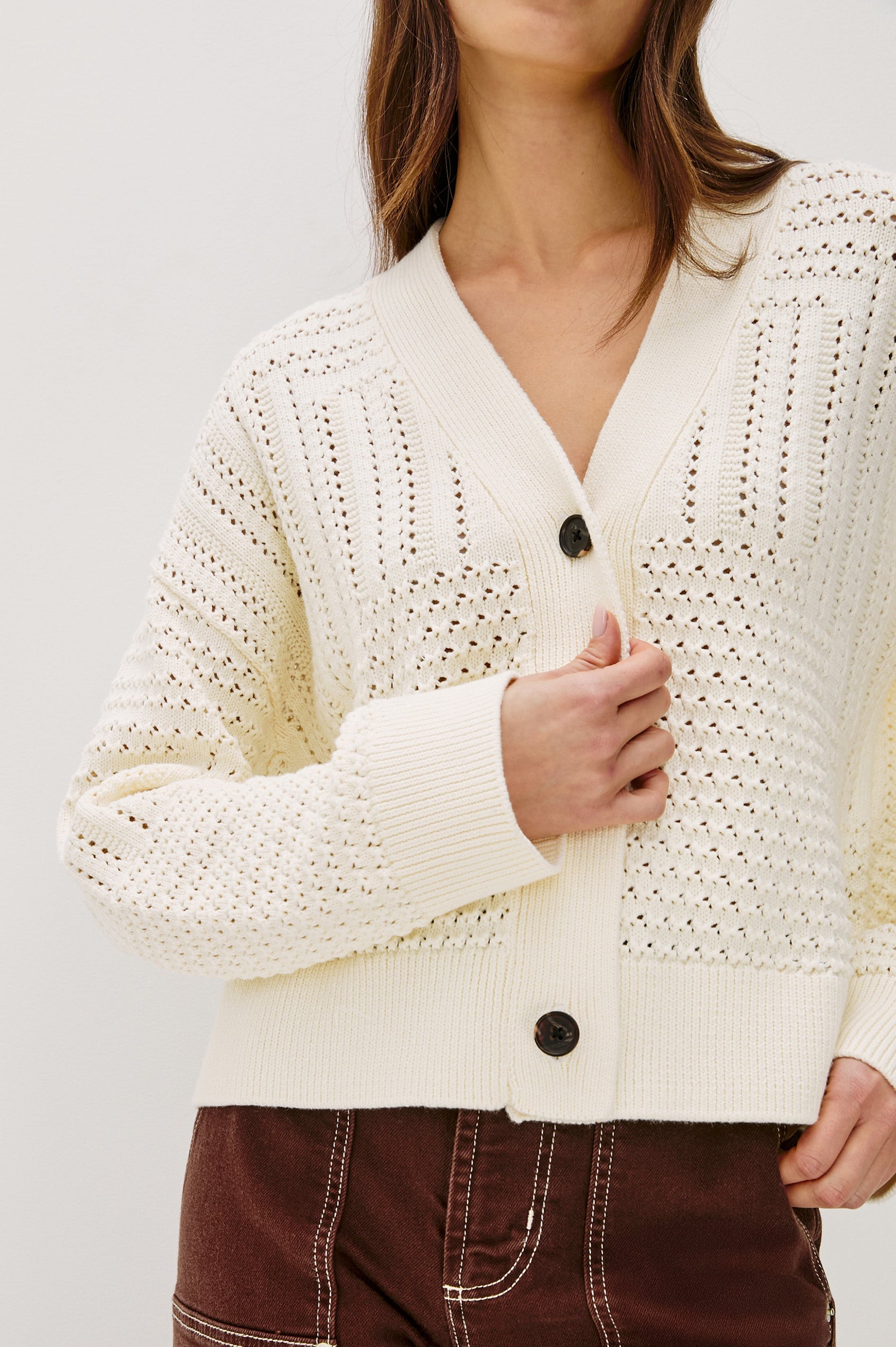 Geneva cropped cardigan sweater with front buttons and pointelle details in Ivory Patchwork Pointelle Colorway - Close up of Details on Model