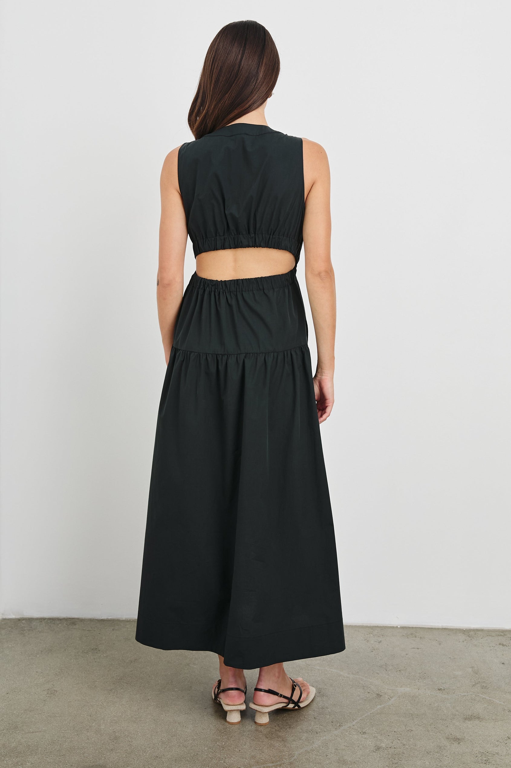 Genevieve Midi Tank Dress with Low V-Neck, Encased Elastic Waistband, Back Waist Cutout and Tiered A-Line Skirt in Black Colorway. Full Body Back View Shown on Model.