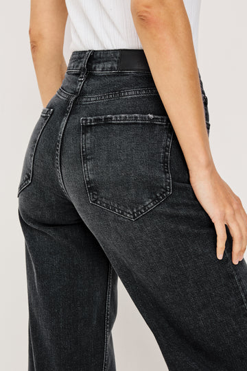 Getty Wide Leg Jean in Dark Wash Denim With High-Rise High-Waisted Fit, Front Button Fly, 5-Pocket Styling in Black Pearl Colorway - Lower Body Back Close Up View Featured on Model