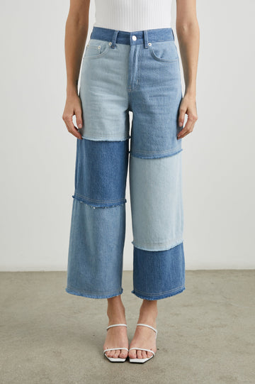 Getty Crop Wide Leg Denim Pants with Belt Loops, Two Front Pockets and Two Back Patch Pockets in Light Indigo Patchwork Colorway, with large patches in blues - Front View Featured on Model