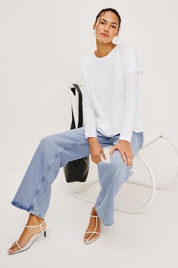 Getty Wide Leg Jean in Light Stretch Denim With High-Rise High-Waisted Fit, Button Fly, and 5-Pocket Styling in Jasper Colorway - Full Body View Featured on Model Sitting