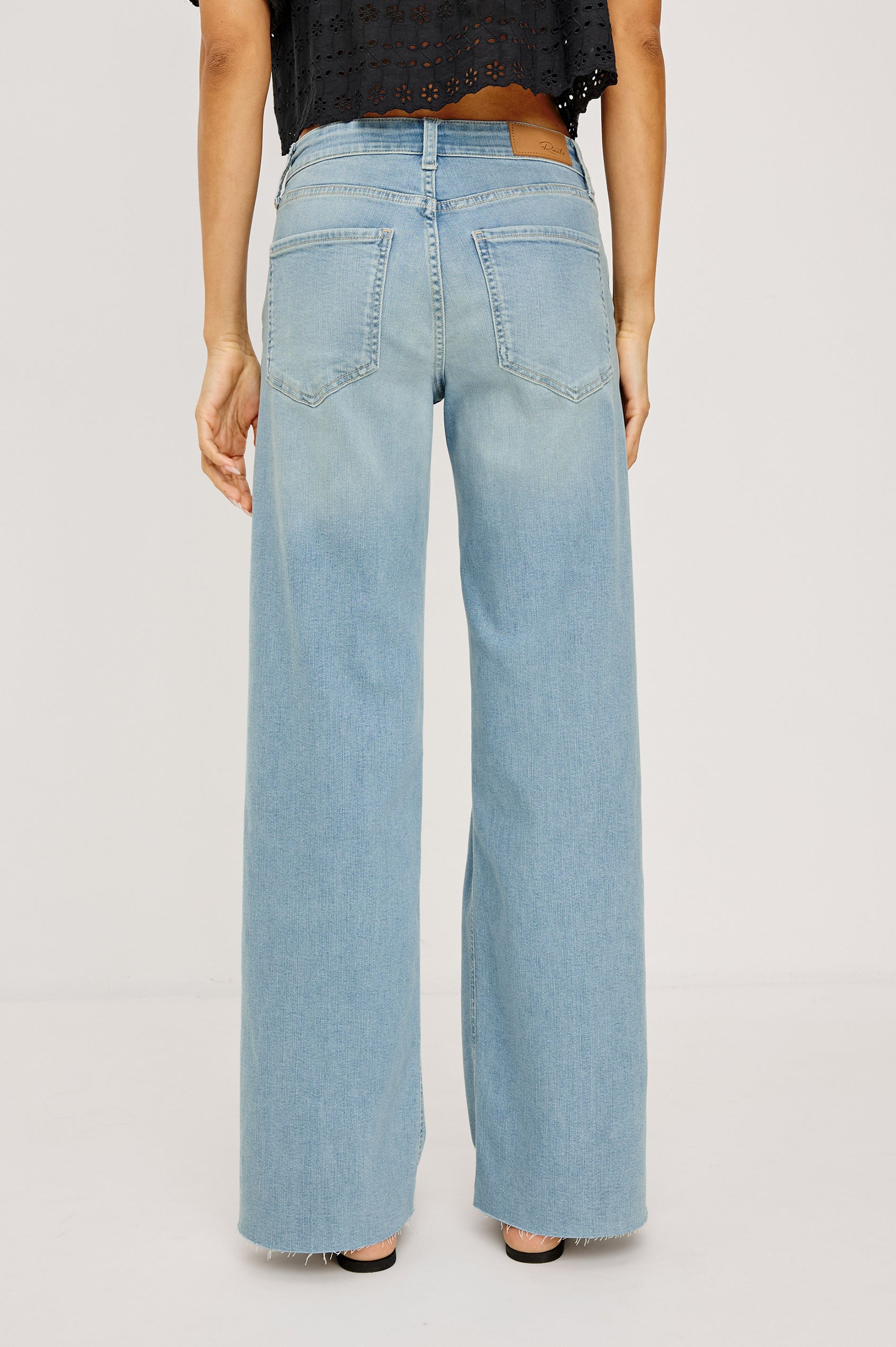 Getty Crop Jean in Light Stretch Denim With Wide Straight Legs, 27″ Inseam, 5-Pockets, Distressed Detailing, Raw Hem, and Zip Fly in Waverider Colorway - Lower Body Back View Featured on Model