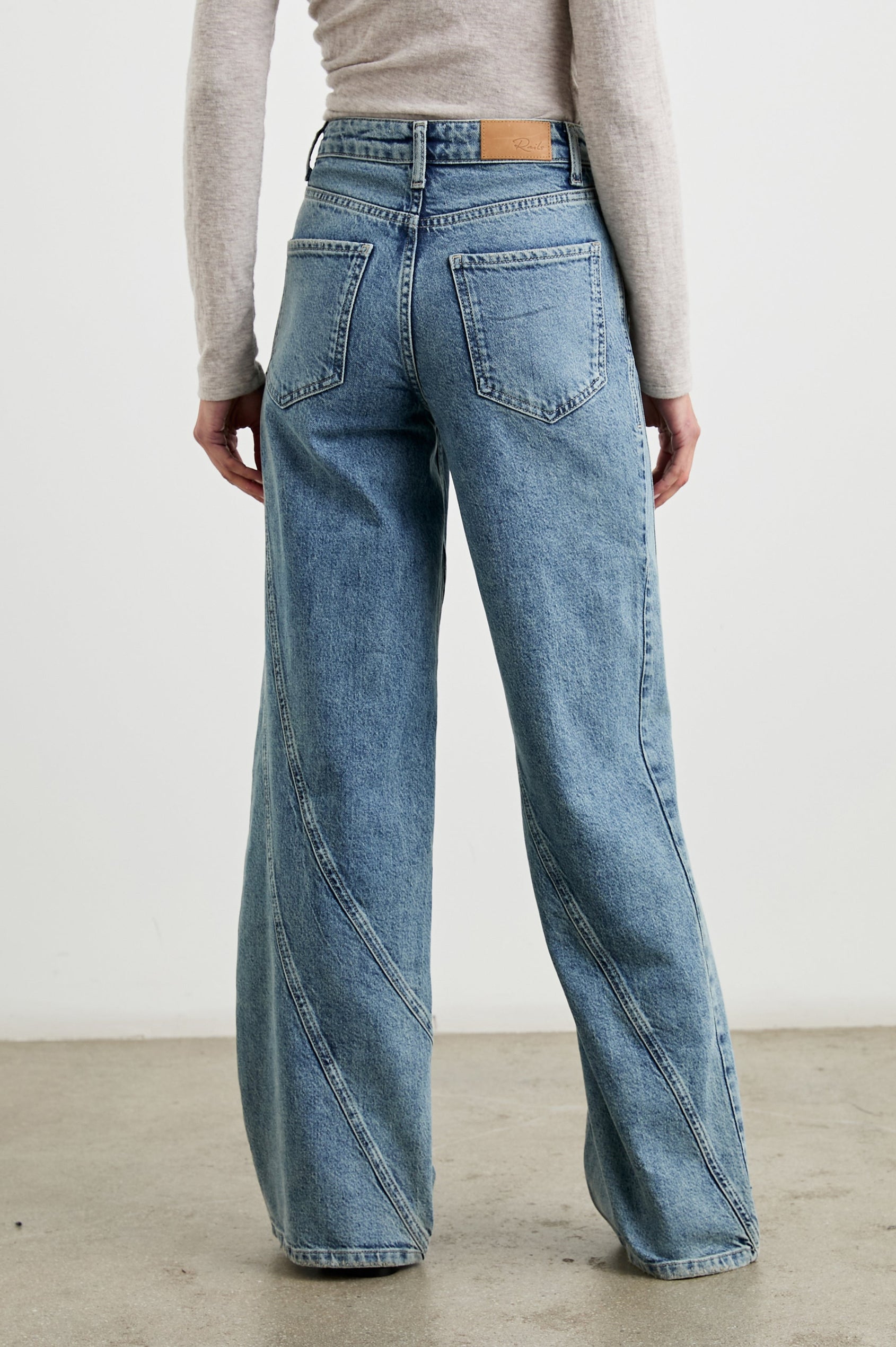 Getty Twist Seam Wide Leg Denim Pants with a Diagonal Seam Across the Leg, Belt Loops, Two Front Pockets and Two Back Patch Pockets in Desert Sky Colorway - Back View Featured on Model