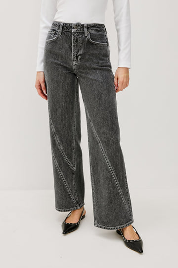 Getty Twist Seam Wide Leg Denim Pants with a Diagonal Seam Across the Leg, Belt Loops, Two Front Pockets and Two Back Patch Pockets in Washed Charcoal Colorway - Front View Featured on Model