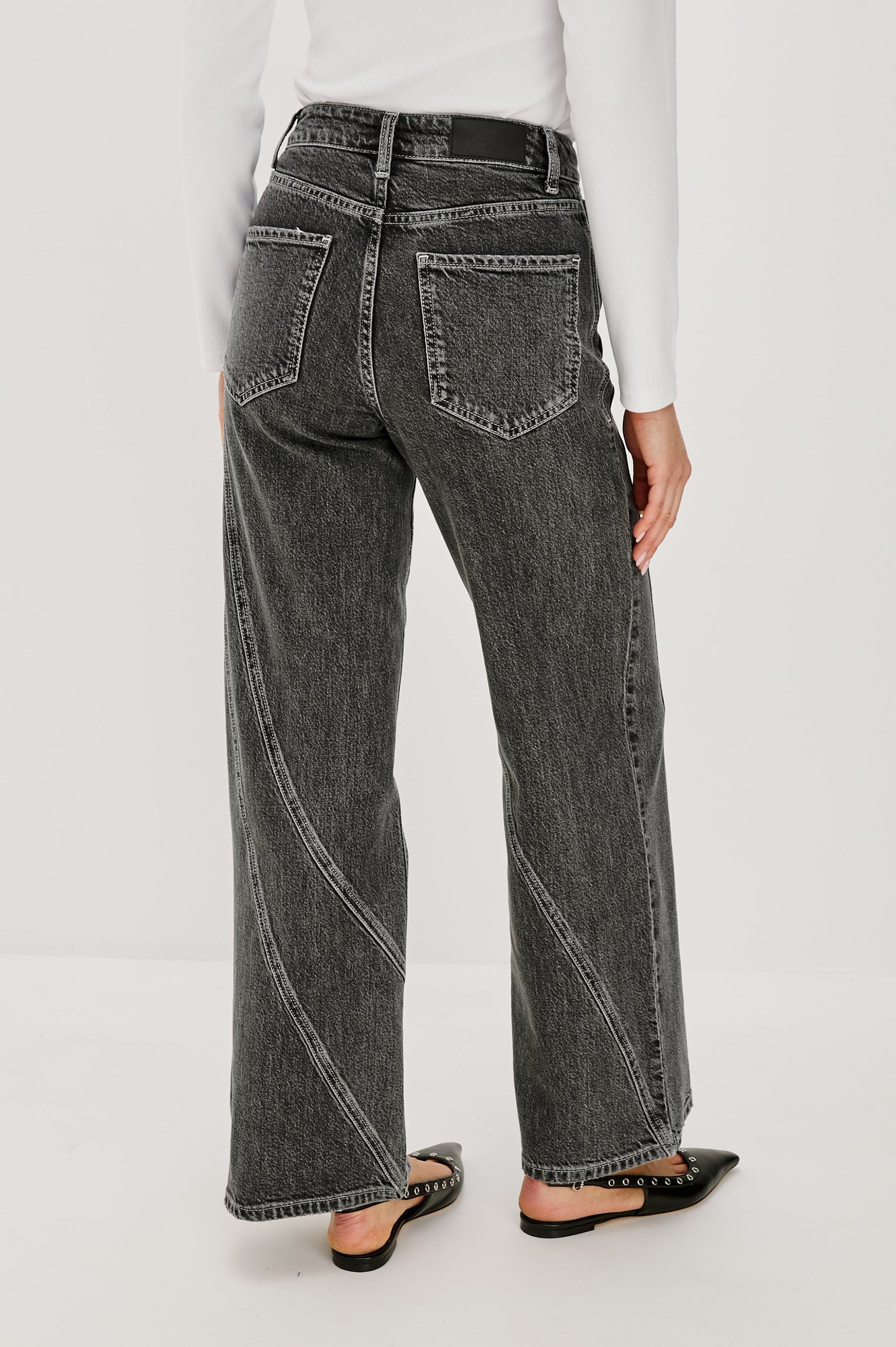Getty Twist Seam Wide Leg Denim Pants with a Diagonal Seam Across the Leg, Belt Loops, Two Front Pockets and Two Back Patch Pockets in Washed Charcoal Colorway - Back View Featured on Model