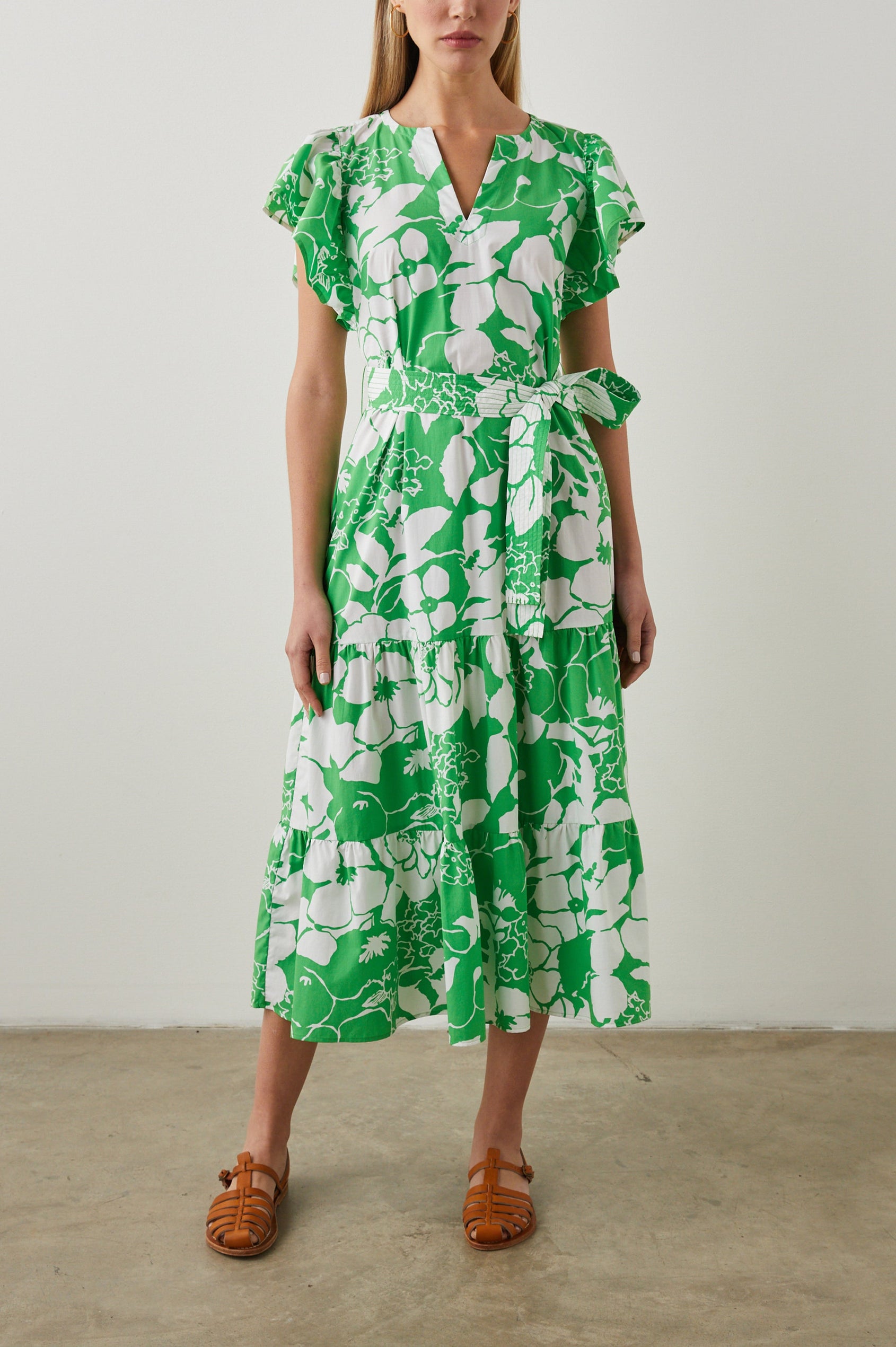 Gia Short-Sleeve Midi Dress with Flutter Sleeves, a V Neck, a Fabric Tie at the Waist, and a Tiered Skirt Green Lotus Colorway, Green and White Flowers - Front Full Body View Featured on Model