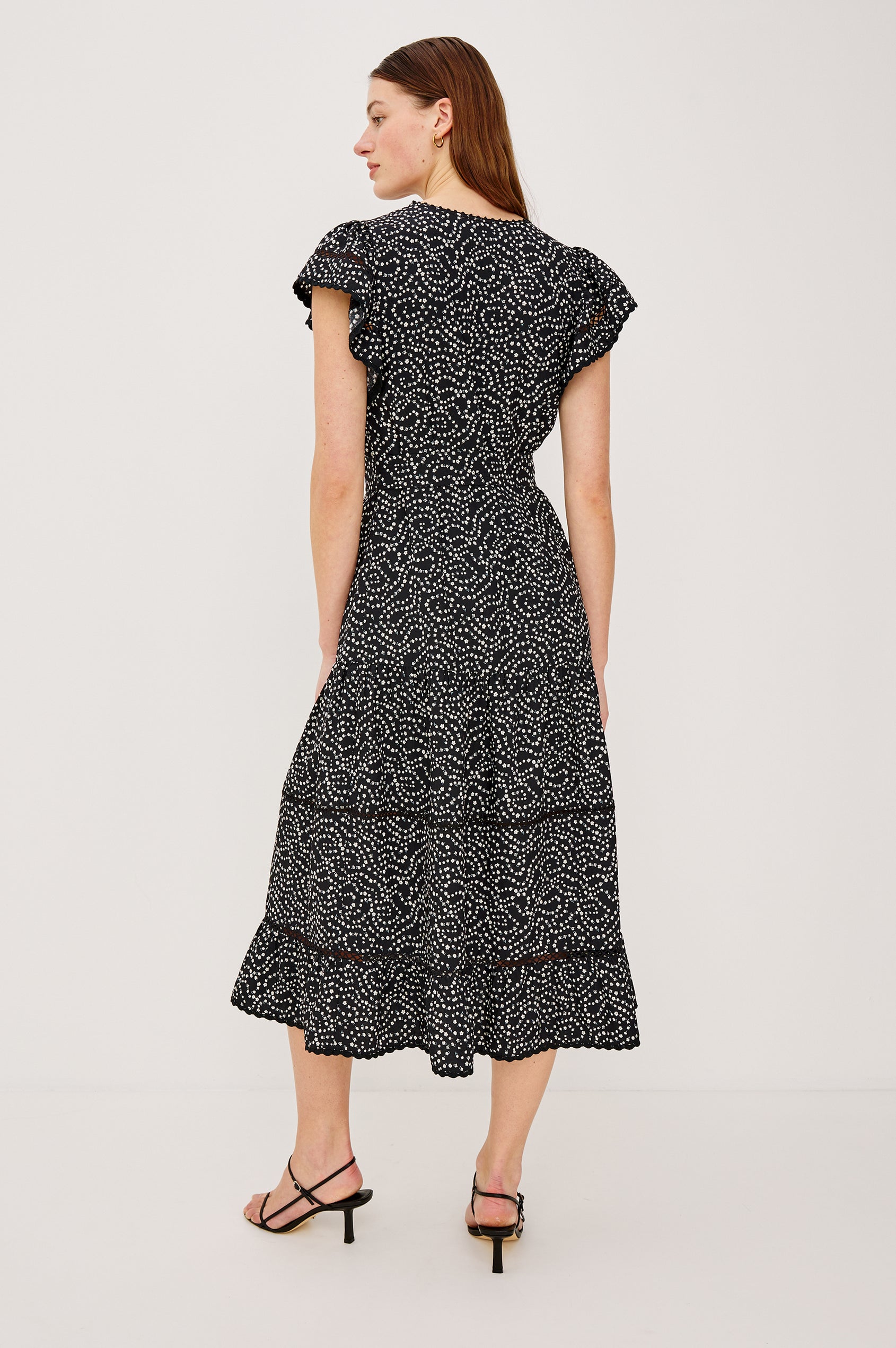 Gia Mini Dress in Crinkle Poplin With Adjustable Waist Ties Split V-Neck Collar Wide Short Sleeves Ladder and Crochet Trim Detailing and Relaxed FIt in Mini Chain Daisies Colorway - Full Body View Featured on Model