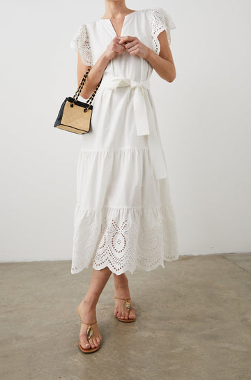 Gia Short-Sleeve Midi Dress with Flutter Sleeves, a V Neck, a Fabric Tie at the Waist, a Tiered Skirt and Eyelet Detail on the Sleeves and Hem in White Colorway - Front Full Body View Featured on Model