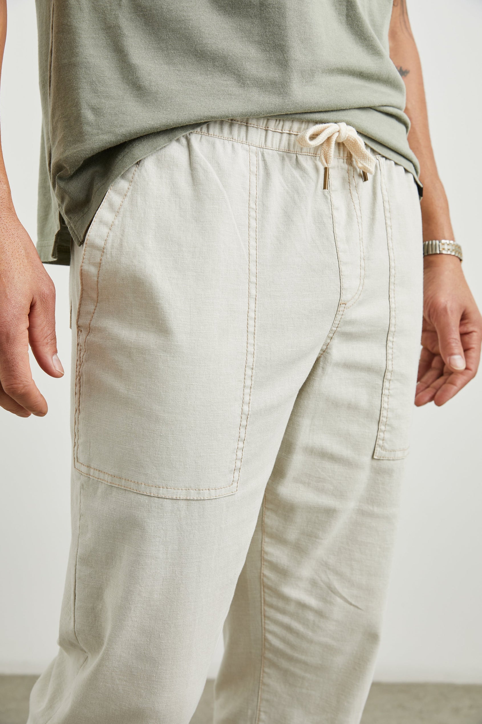 Gobi Pants with Drawstring Waist, Two Large Front Pockets and Two Back Buttoned Patch Pockets in Natural Colorway - Front View Featured on Model