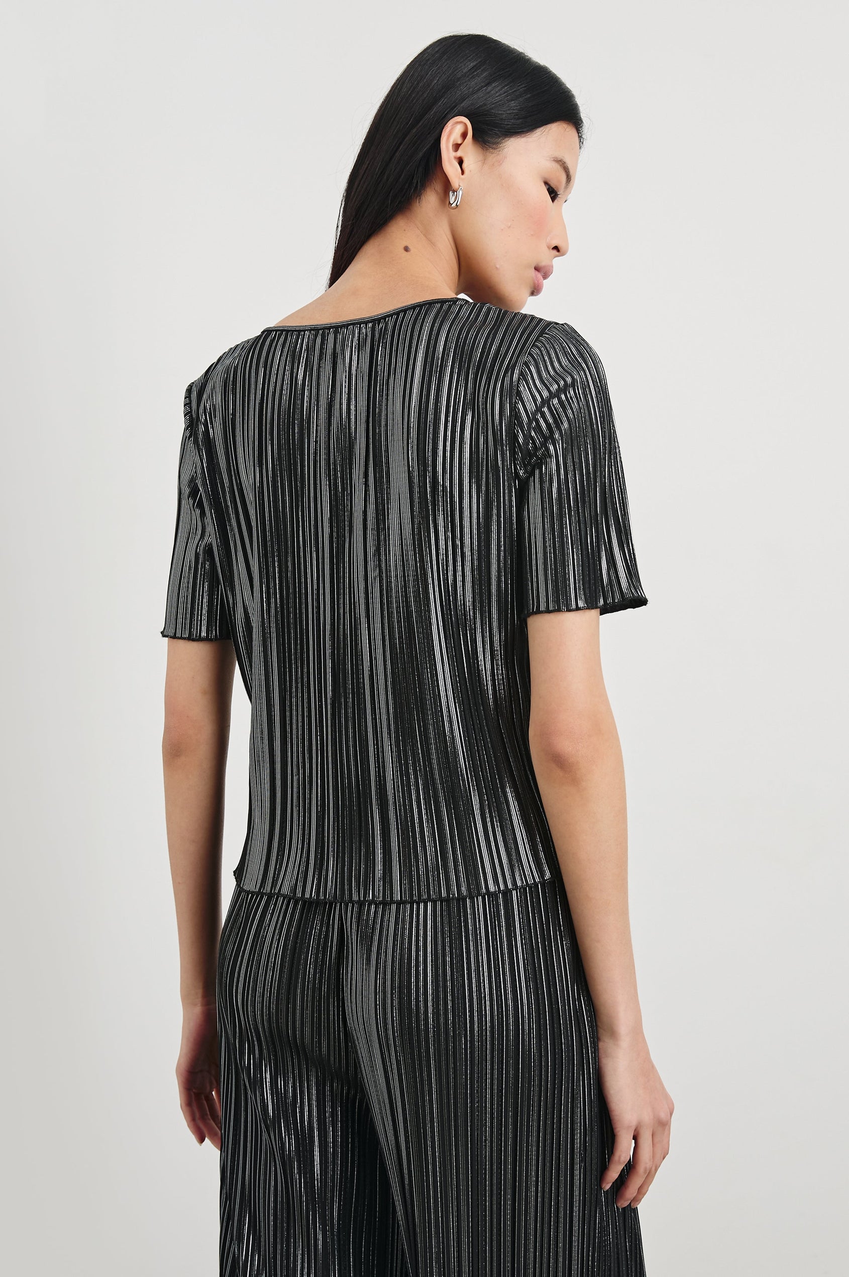 Goldie Short Sleeve Top with a Crew Neck in Gunmetal Colorway, with Thin Vertical Stripes of Back, White and Greys - Back View Featured on Model