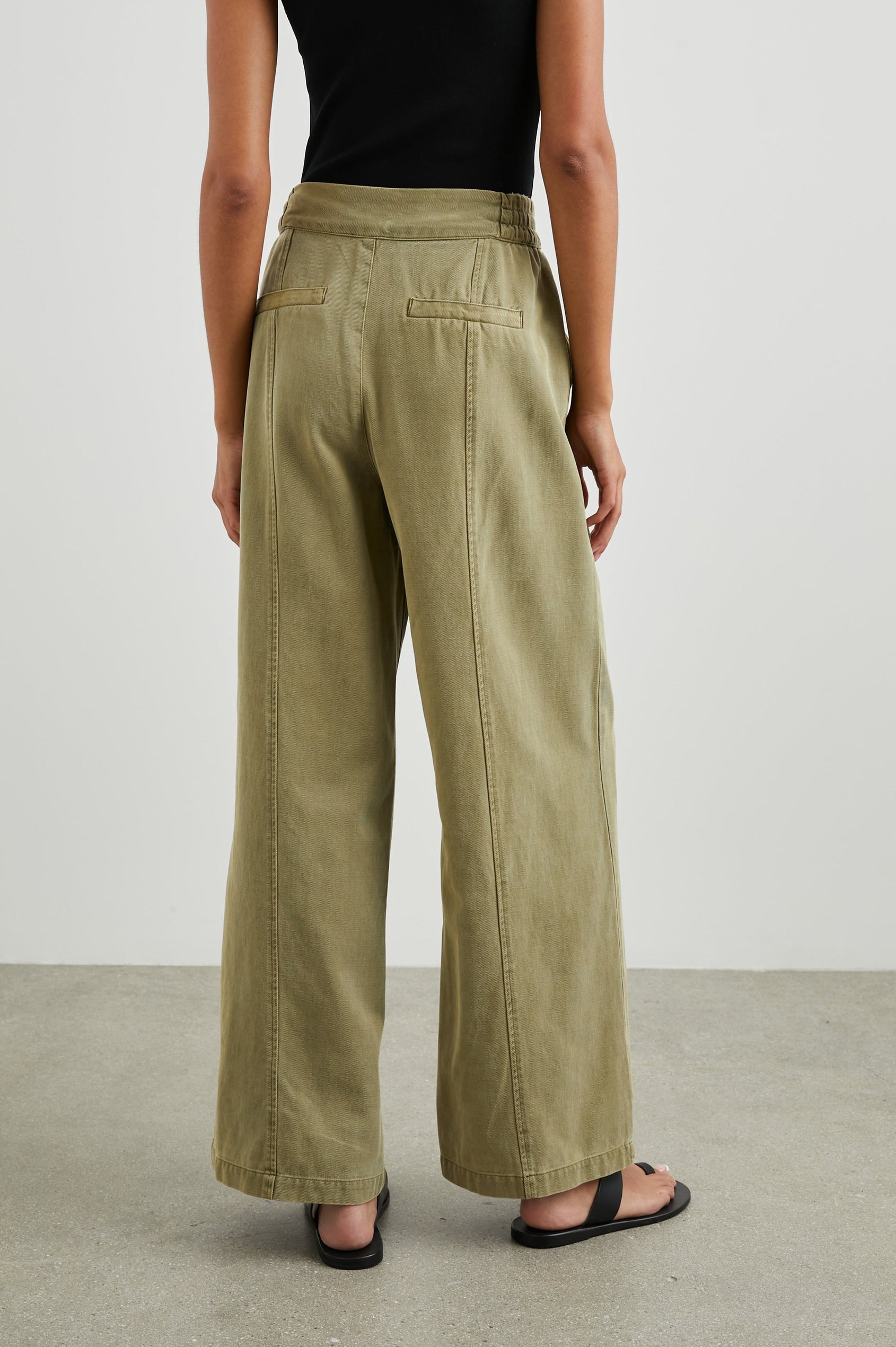 Greer Pants with Two Large Front Pockets, Two Back Welt Pockets and Vertical Seams Down the Front and Back Legs in Canteen Colorway - Back View Featured on Model 