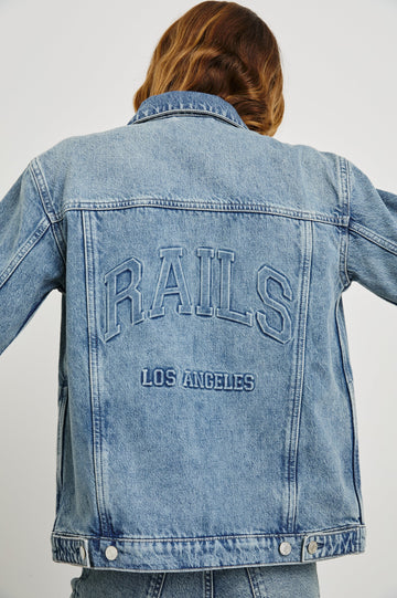 Grove Boyfriend Trucker Denim Jacket with Button Closure, Two Front Pockets, Two Chest Button Flap Pockets, Front Vertical Seams in Embossed Indigo Colorway - Back View Featured on Model  