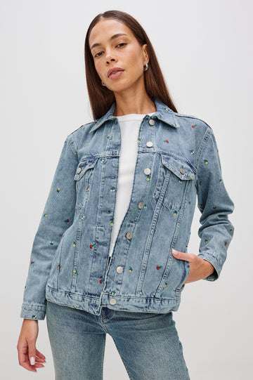 Grove Boyfriend Trucker Denim Jacket with Button Closure, Two Front Pockets, Two Chest Button Flap Pockets, Front Vertical Seams in Flower Field Colorway, with Embroidered Daisies in Yellow, Red and White - Front View Featured on Model  