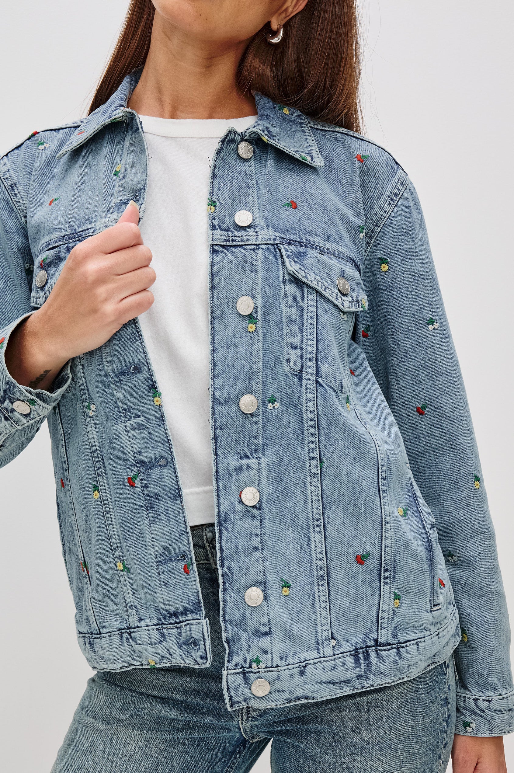 Grove Boyfriend Trucker Denim Jacket with Button Closure, Two Front Pockets, Two Chest Button Flap Pockets, Front Vertical Seams in Flower Field Colorway, with Embroidered Daisies in Yellow, Red and White - Front View Featured on Model  