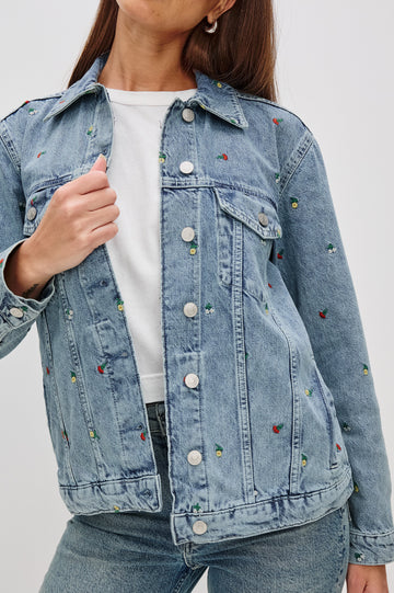 Grove Boyfriend Trucker Denim Jacket with Button Closure, Two Front Pockets, Two Chest Button Flap Pockets, Front Vertical Seams in Flower Field Colorway, with Embroidered Daisies in Yellow, Red and White - Front View Featured on Model  
