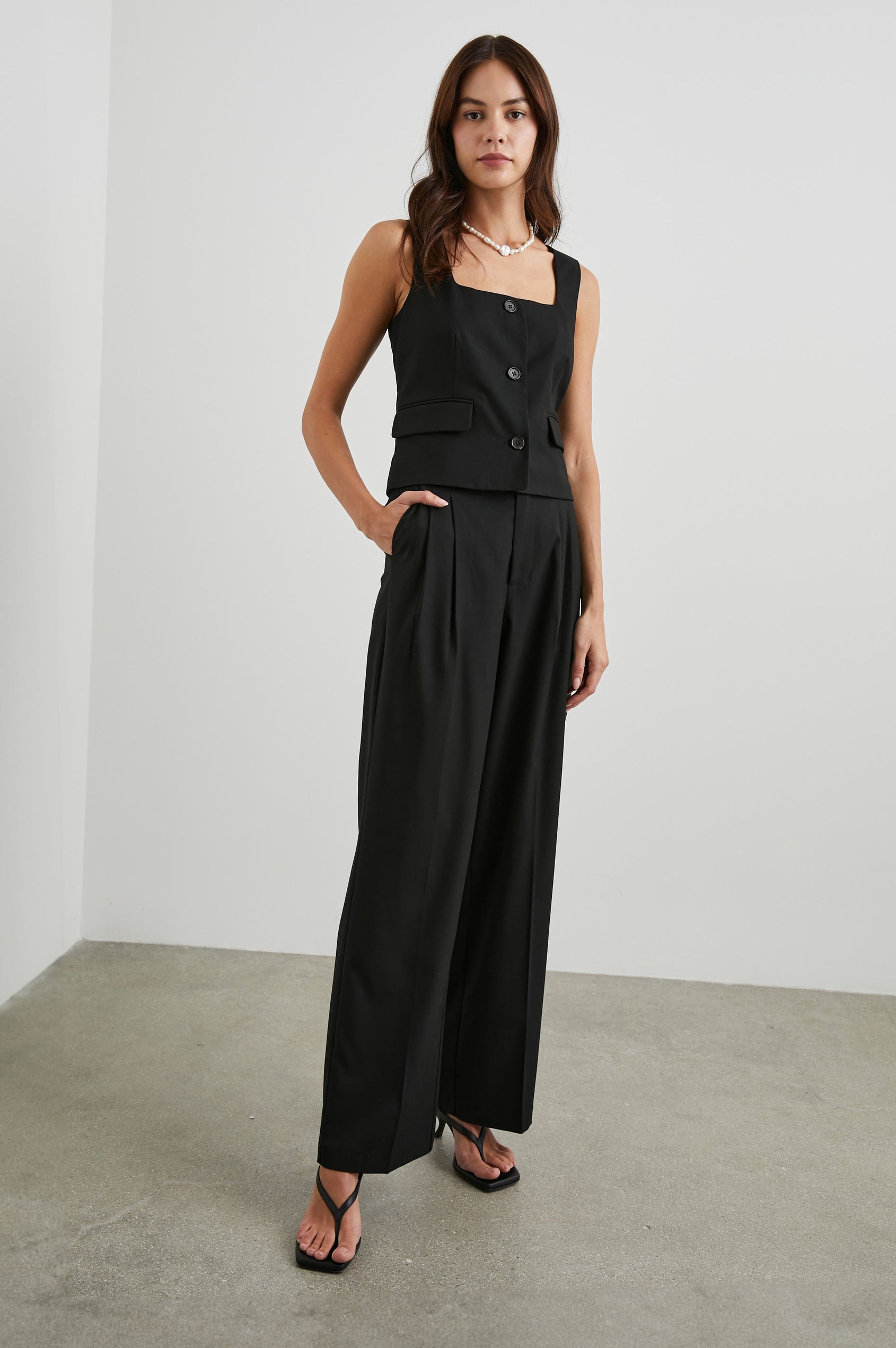 Guilia Cropped Vest with a Square Neckline, Button Closure and Two Front Flap Pockets in Black Twill Colorway - Front Full Body View Featured on Model 