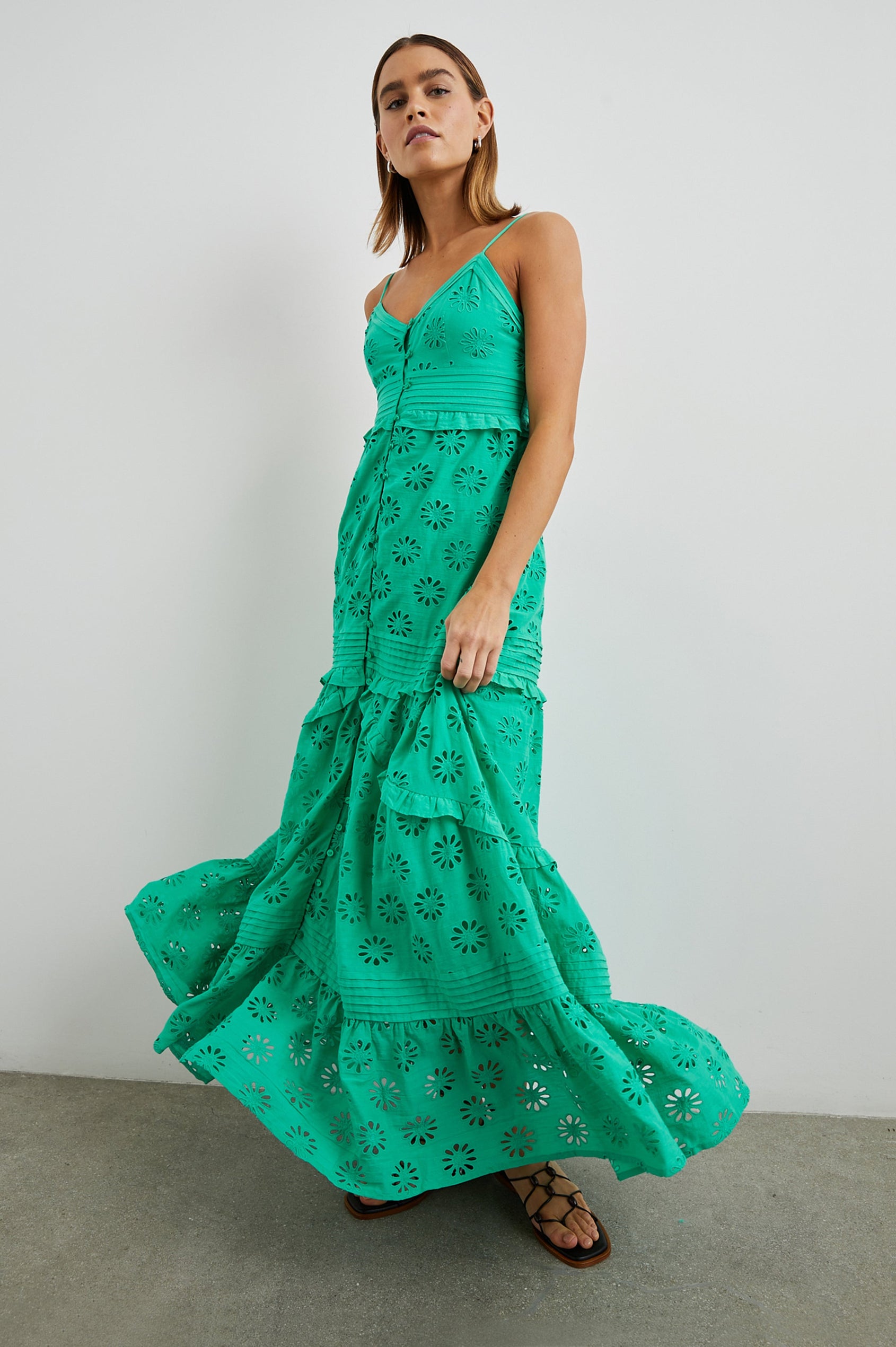 Henrietta Sleeveless Maxi Dress with Adjustable Spaghetti Straps, a Deep V Neck, Buttons Down the Front, a Shirred Back Bodice, a Tiered Skirt with Ruffles and Horizontal Pleats, and a Floral Eyelet Design in Jade Colorway - Front Full Body View Featured on Model 