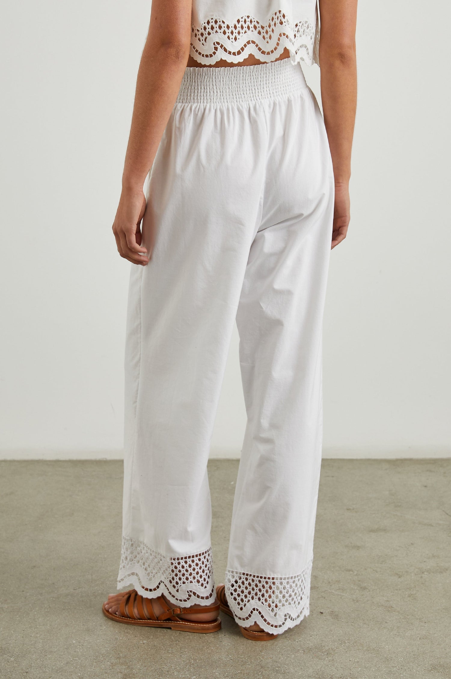 Henrik Pants with a Shirred Waist, Two Front Pockets and an Eyelet Design at the Hems in White Colorway - Back View Featured on Model 
