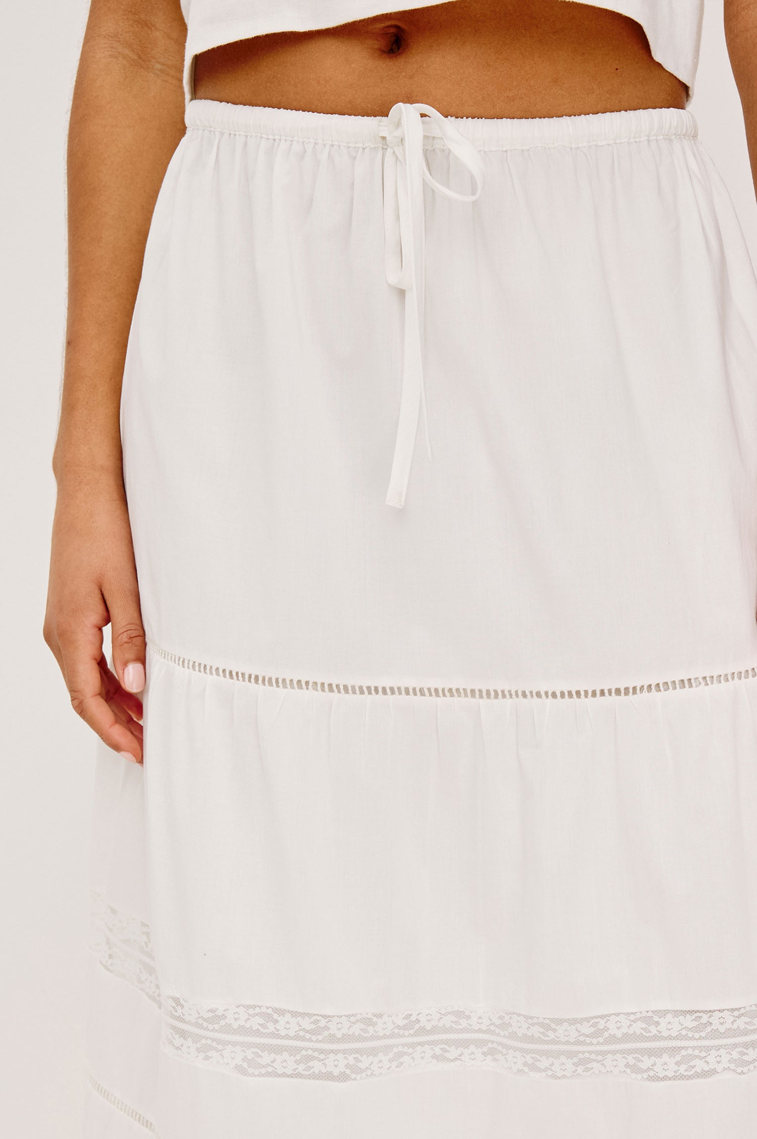 Hettie High-Waisted Maxi Skirt in Cotton Voile With Ladder Trim, Lace Insets, Self-Tie Waist, Relaxed Fit, and Fully Lined in White Colorway - Lower Body Close Up Front View Featured on Model