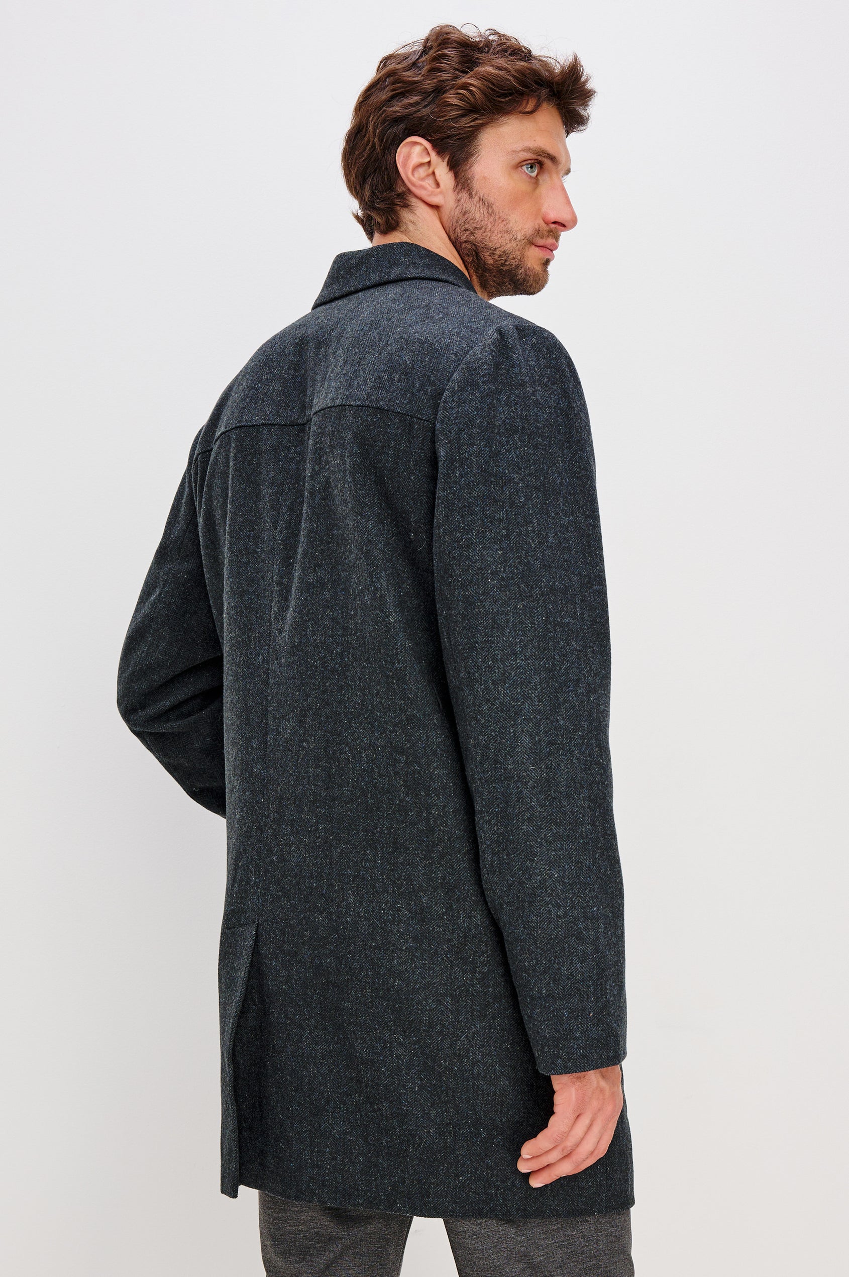 Hockney is a traditional top coat, wool-blended and lined with welt pockets, interior pockets on both sides (invisible zipper and welt), and a back vent, in Celestial Tweed Color. Back view featured on model.