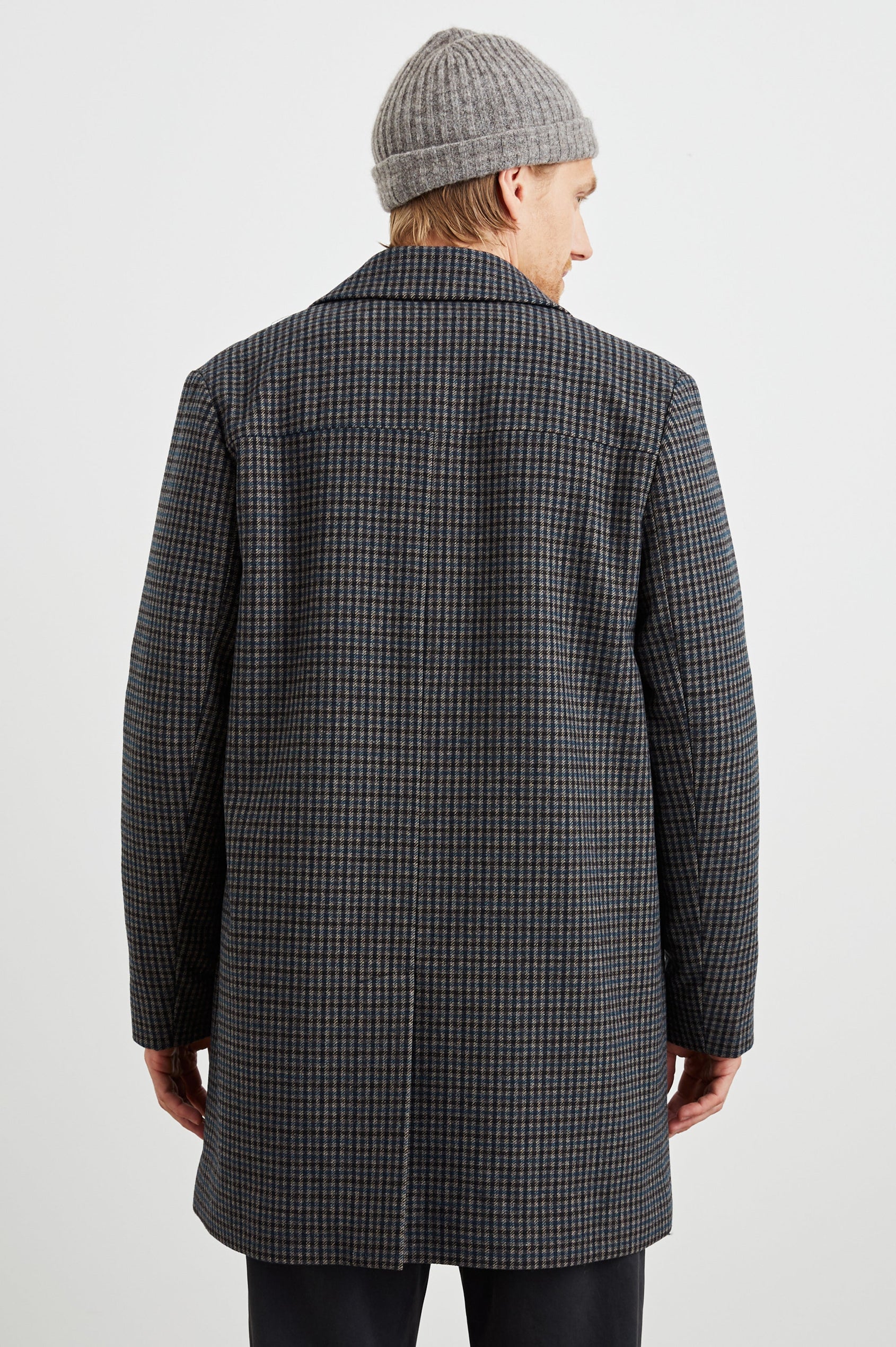 Hockney Mid-Thigh Length Overcoat with Button Closure, Two Front Pockets, and a Back Vent in Grey Check Plaid Colorway, a plaid in Grey, Black and Blue - Back View Featured on Model