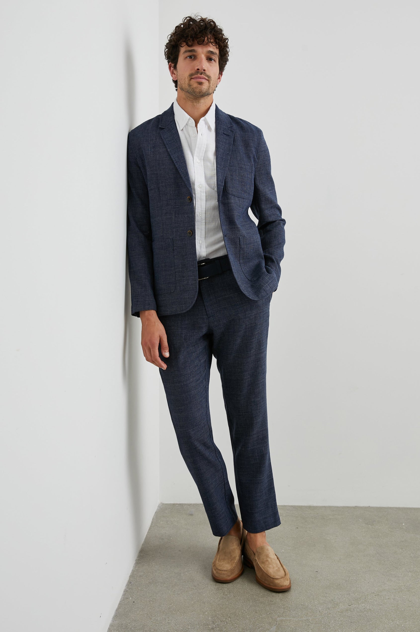 Idris Blazer with Two Button Closure, Two Front Patch Pockets, a Chest Patch Pocket and Three-Button Cuffs in Navy Melange Colorway - Front Full Body View Featured on Model