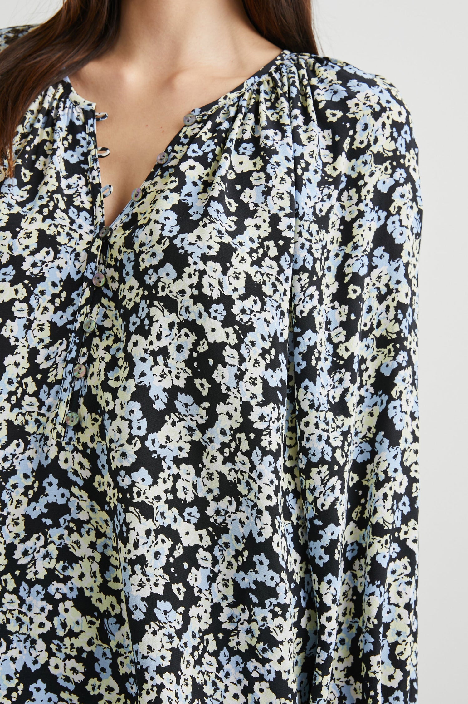 Indi Top with a V Neckline with a Button Placket, Pleating at Back Neckline and Elastic Cuffs in Midnight Meadow Floral Colorway, with cream and blue flowers on midnight - Front View Featured on Model