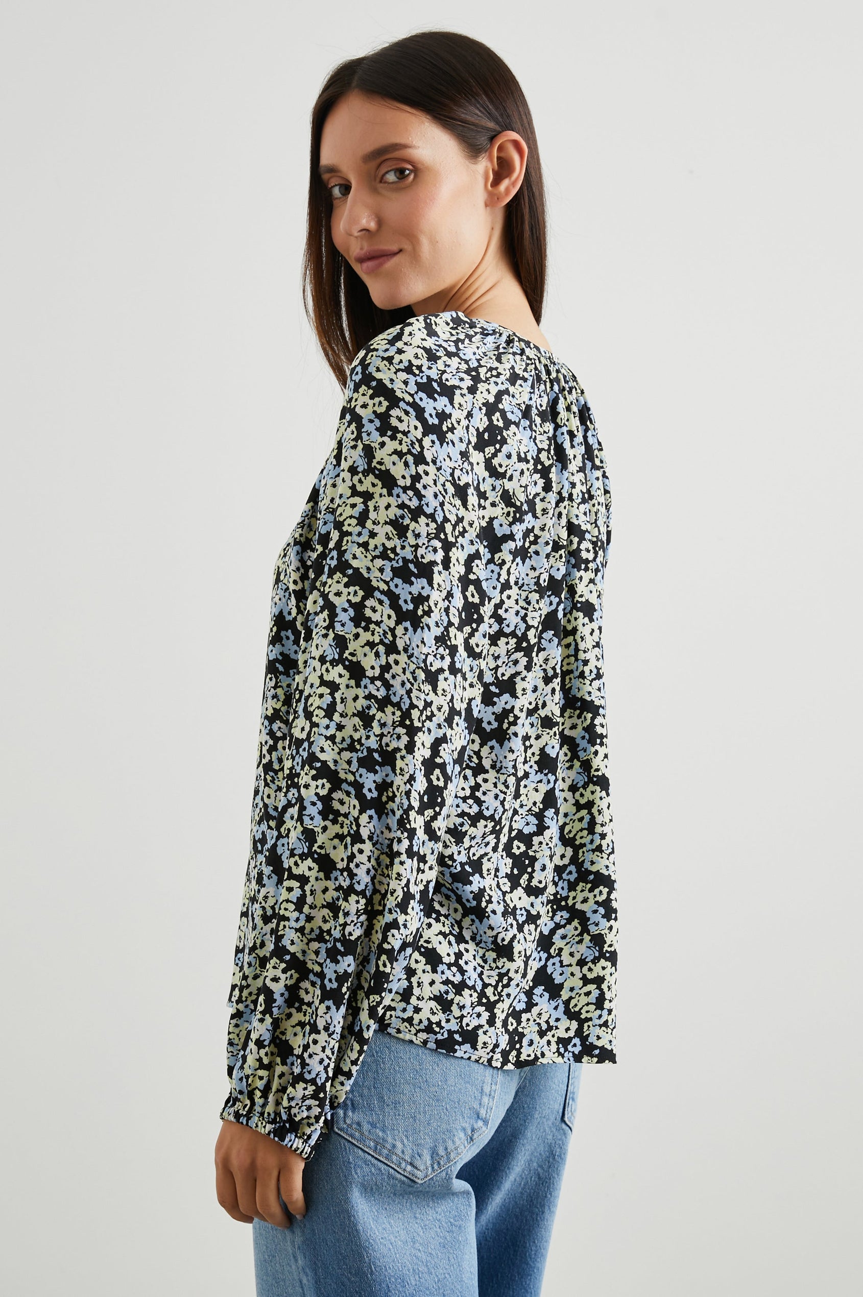 Indi Top with a V Neckline with a Button Placket, Pleating at Back Neckline and Elastic Cuffs in Midnight Meadow Floral Colorway, with cream and blue flowers on midnight - Side View Featured on Model