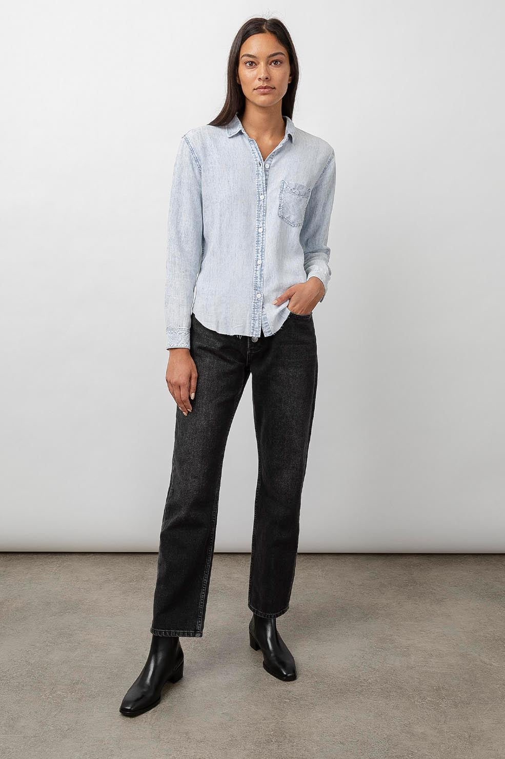 Ingrid Raw Hem, Long Sleeve Denim Button Up with a Chest Patch Pocket in Light Acid Wash Colorway - Front Full Body View Featured on Model