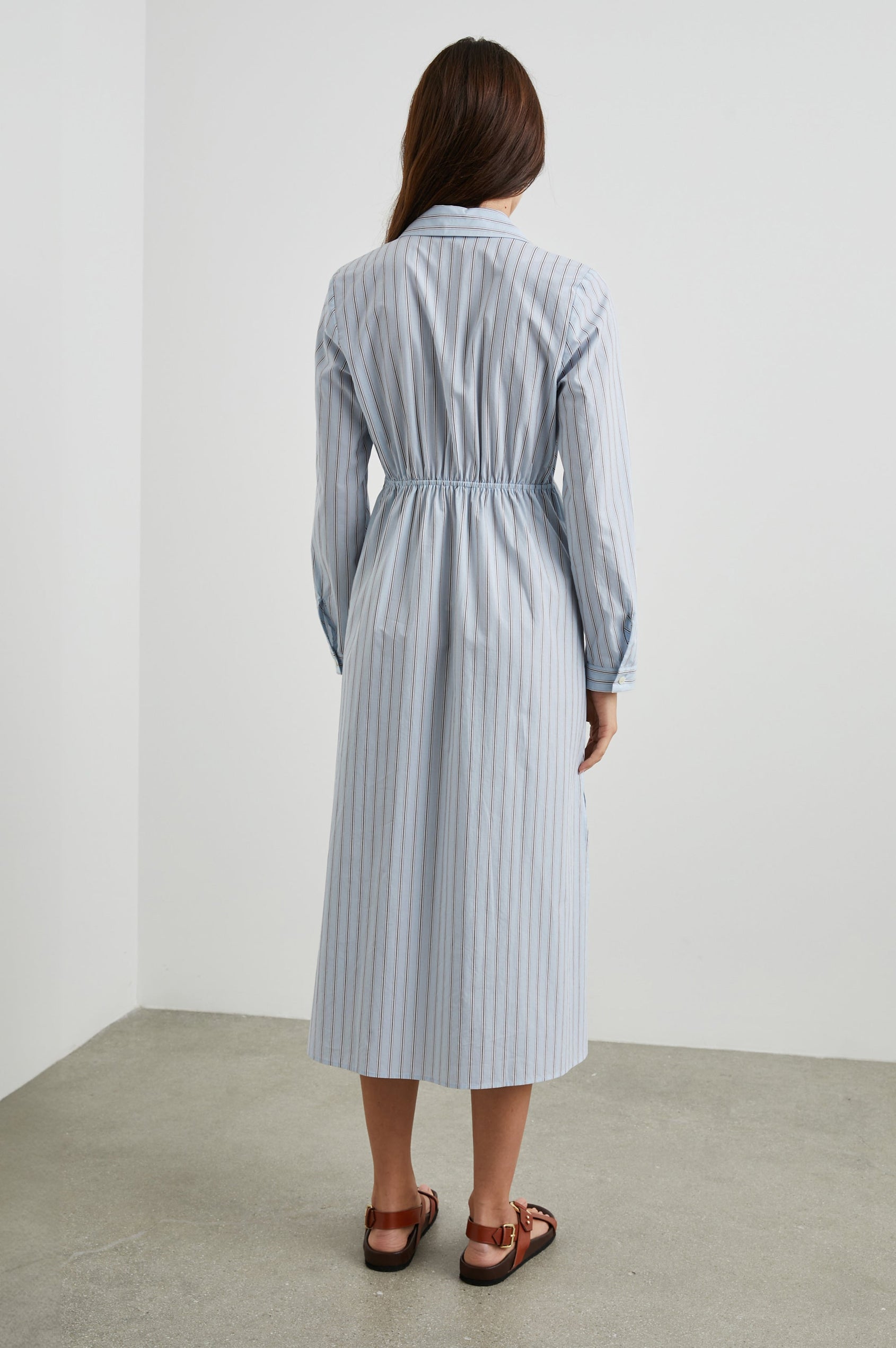 Irie Long-Sleeve Midi Dress with an Overlapped V Neck, Buttons Down the Skirt, a Side Thigh Slit, a Collar and a Seam at the Waist in Hampton Stripe Colorway, Black and White Diagonal and Vertical Stripes on Light Blue - Back Full Body View Featured on Model 