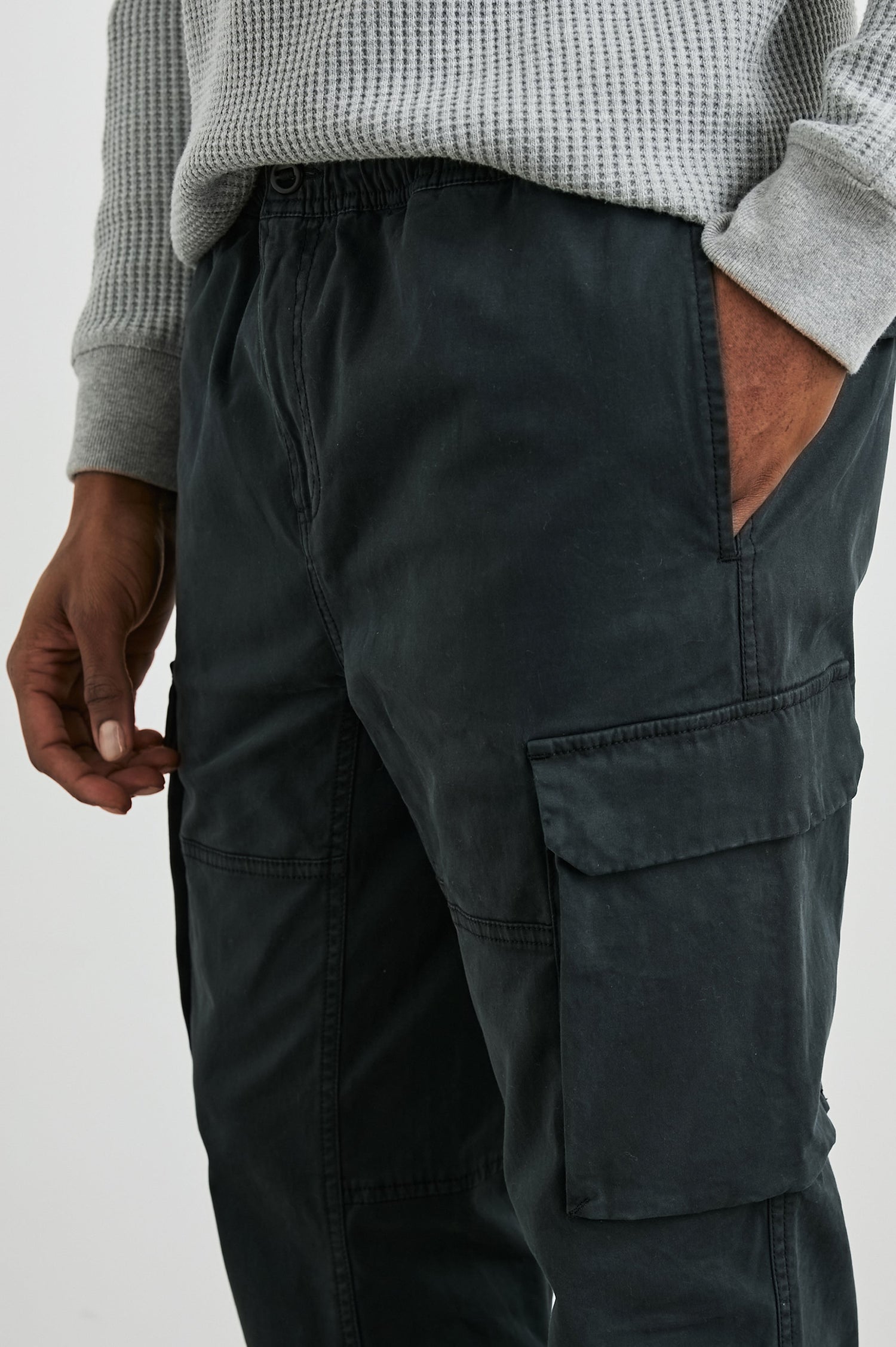 Jaiden Pants with an Elastic, Button Waist with Zip Fly, Two Front Pockets, Two Side Flap Pockets, and Two Back Flap Pockets in Black Colorway - Front View Featured on Model