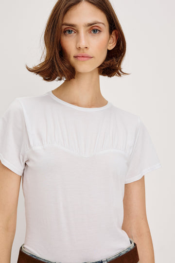 Janis short-sleeve cotton t-shirt with a sweetheart neckline and gathered, shirred detailing at the chest in White Colorway - front detailed view featured on model with shirt tucked in and styled with a western belt.