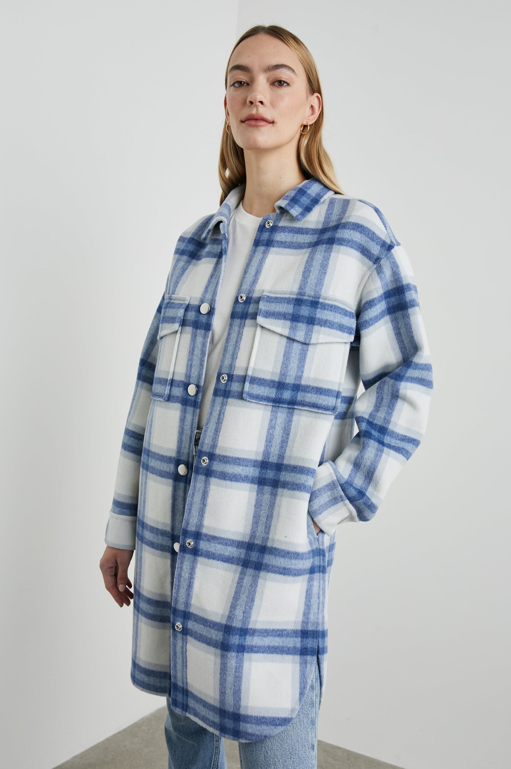 Jaro Mid-Thigh Length Coat with Snap Closure, Snap Cuffs, Two Chest Flap Pockets, Two Front Pockets and Side Hem Slits in Ivory Bay Colorway, an Ivory and Blue Plaid - Front View Featured on Model 