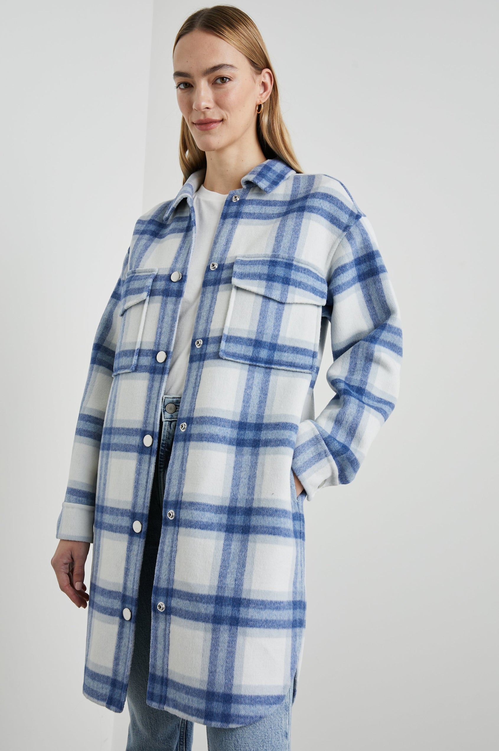 Jaro Mid-Thigh Length Coat with Snap Closure, Snap Cuffs, Two Chest Flap Pockets, Two Front Pockets and Side Hem Slits in Ivory Bay Colorway, an Ivory and Blue Plaid - Front View Featured on Model 