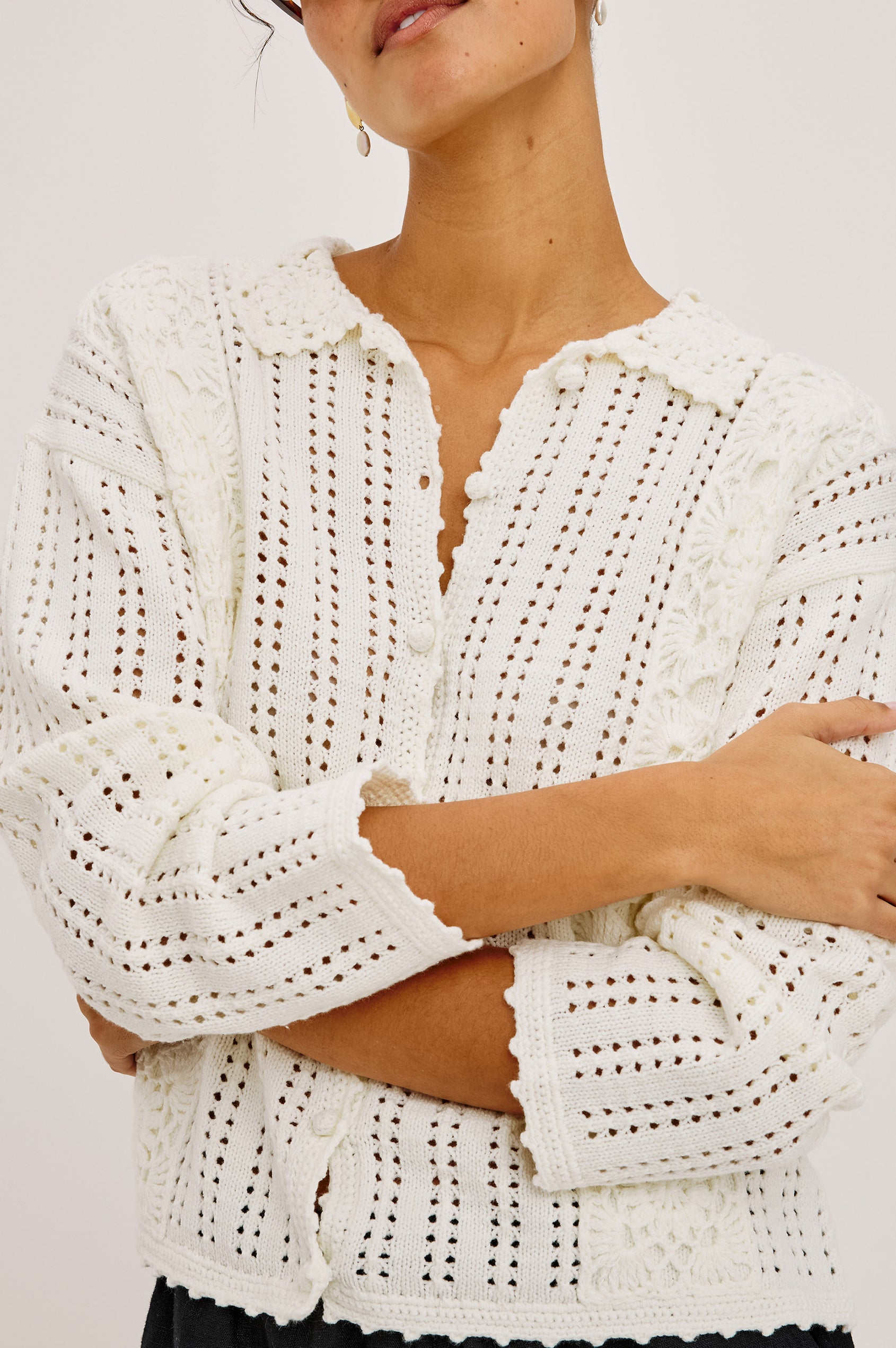 Jenni Cardigan Sweater in Open Weave Cotton Blend Pointelle Knit With Long Sleeves, Crochet Button-Loop Closures, Floral Detailing, and Scalloped Trim in Ivory Colorway - Upper Body Front View Featured on Model