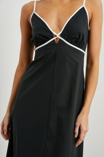 Jessa Sleeveless Maxi Dress with Adjustable Spaghetti Straps, a Deep V Neck with a Cutout, a Shirred Back and White Trim on the Bodice in Black Colorway - Front View Featured on Model 