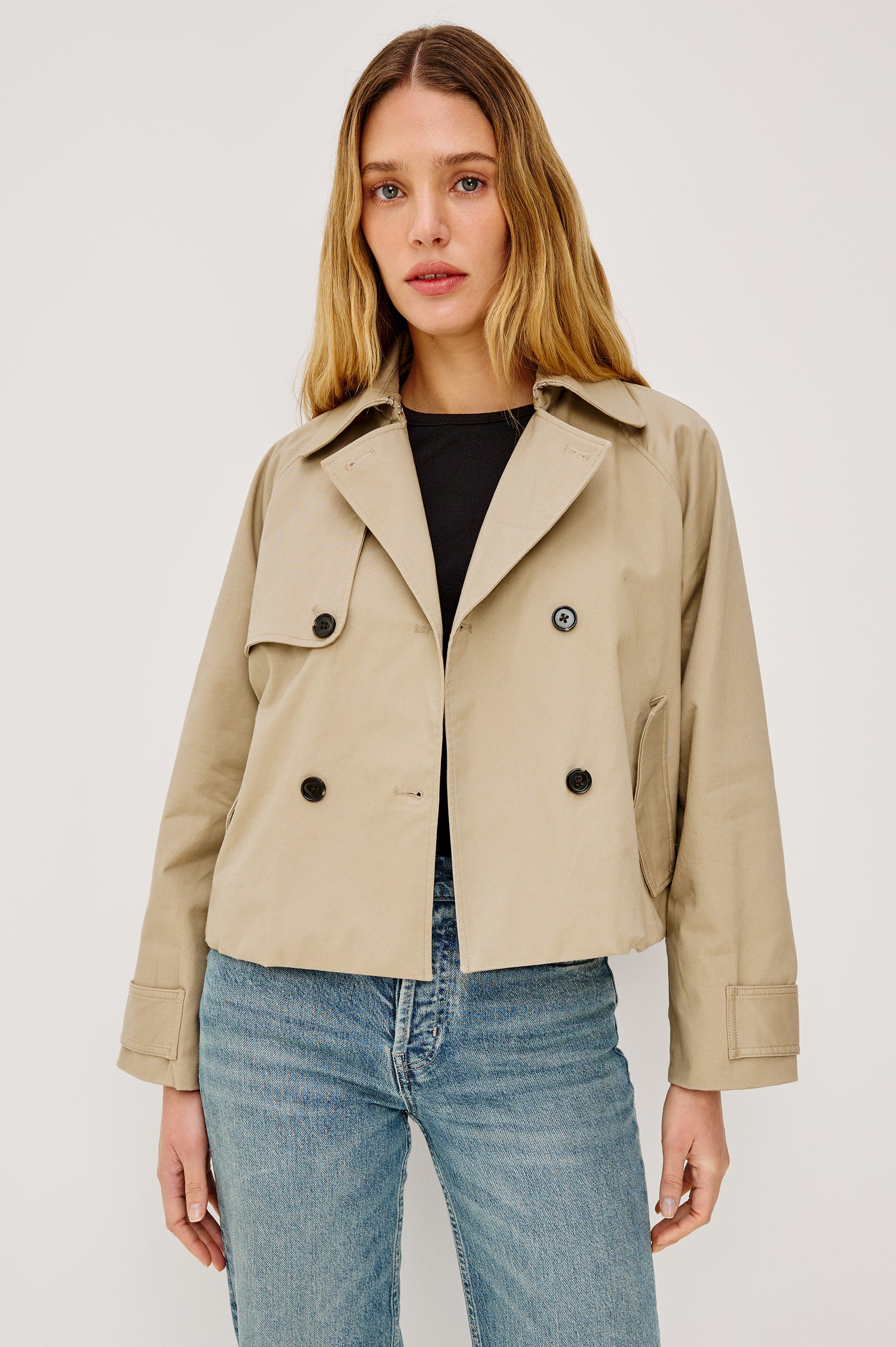 Jett Double Breasted, Cropped Trench Jacket, Lapel, Adjustable Cuff Belt, Side Pockets and Elasticated Hem in Taupe Colorway. Front View Featured on Model.