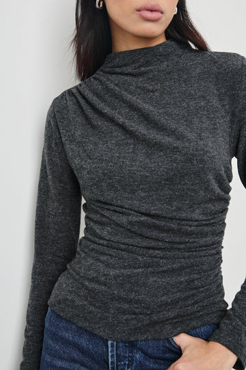 Joelle Long Sleeve Top with An Asymmetrical Mock Neck and Shirring on the Right Shoulder in Charcoal Colorway - Front View Featured on Model