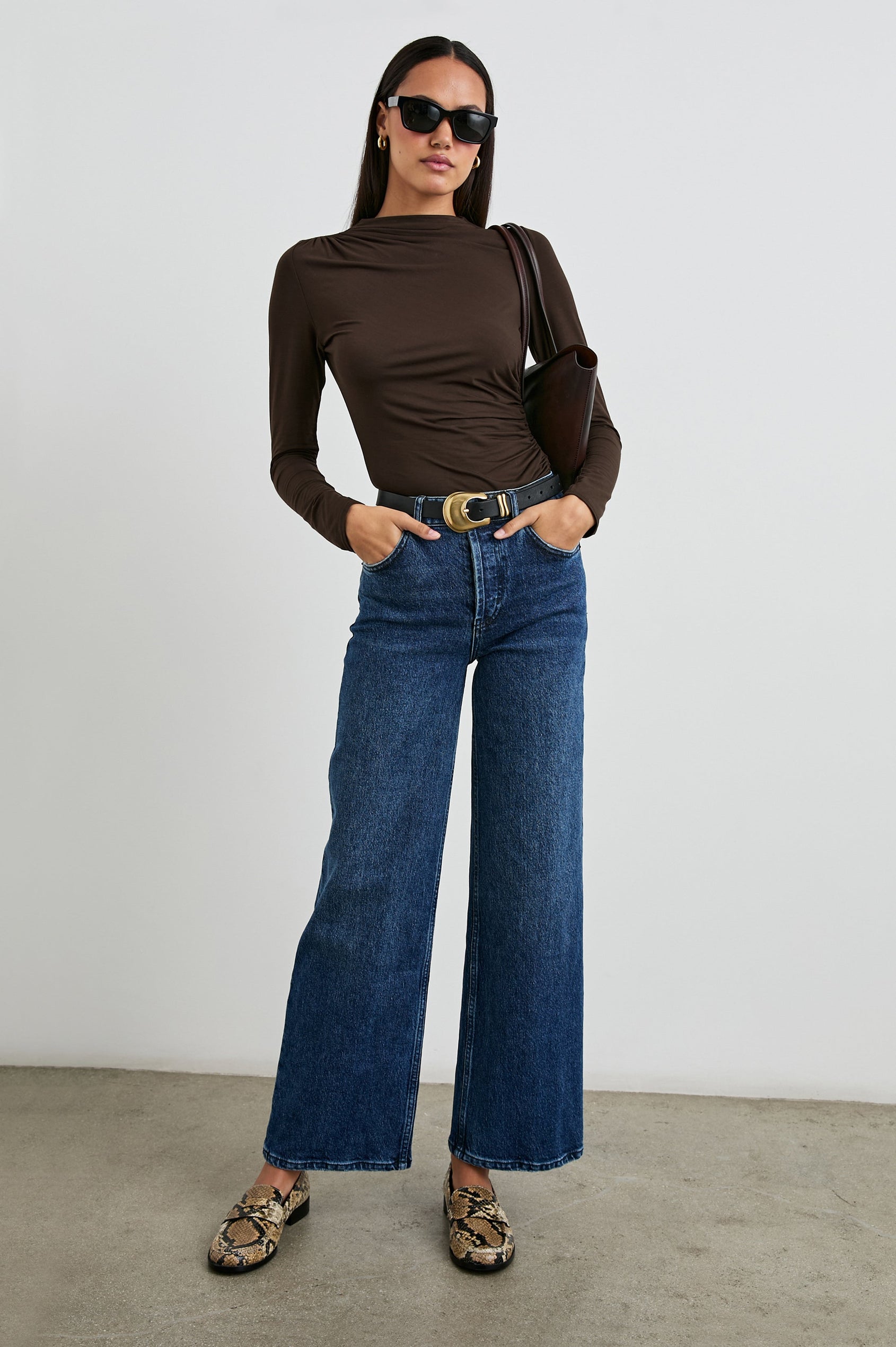 Joelle Long Sleeve Top with An Asymmetrical Mock Neck and Shirring on the Right Shoulder in Espresso Colorway - Front Tucked Full Body View Featured on Model