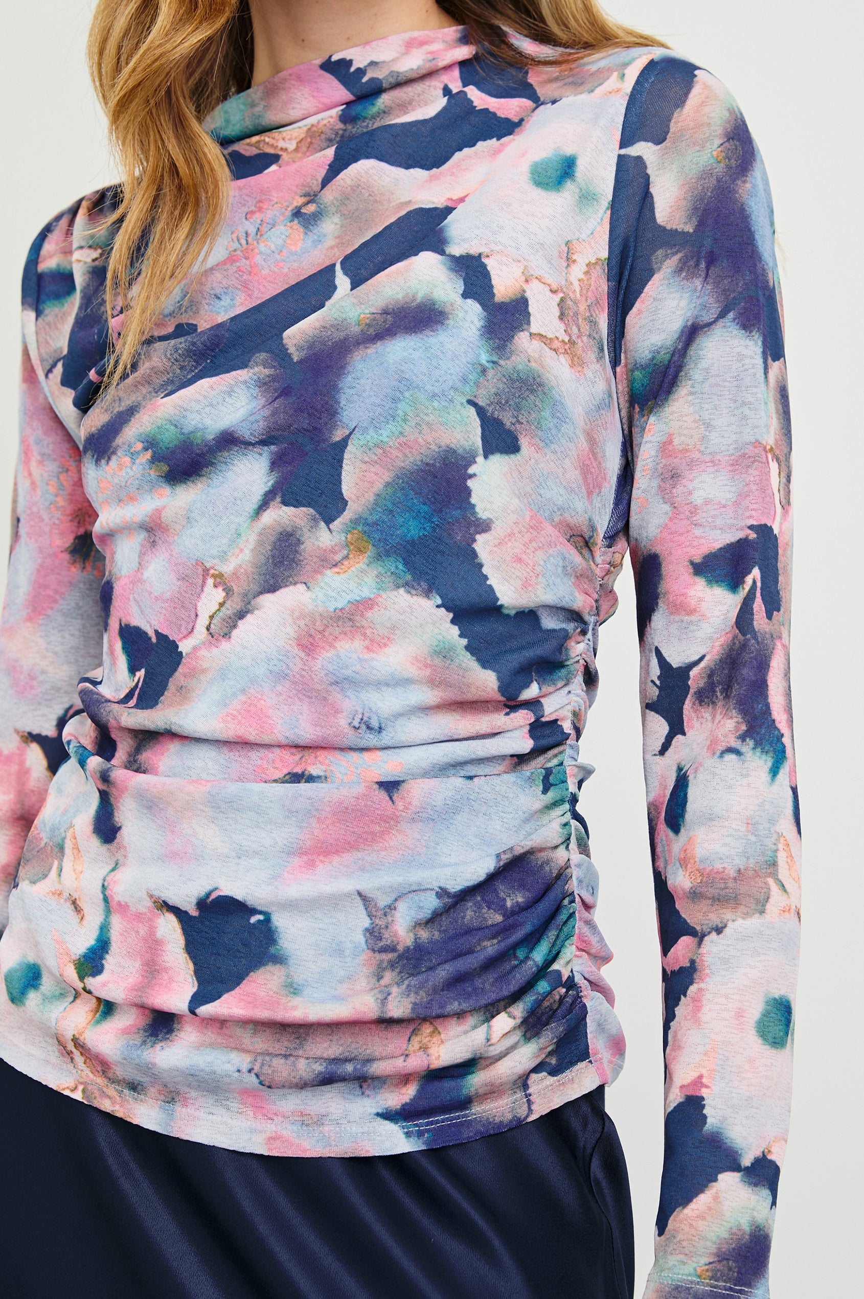 Joelle Long Sleeve Top with An Asymmetrical Mock Neck and Shirring on the Right Shoulder in Midnight Verbena Colorway, with slightly abstract flowers in pinks, purples, blues and oranges on Midnight - Front View Featured on Model