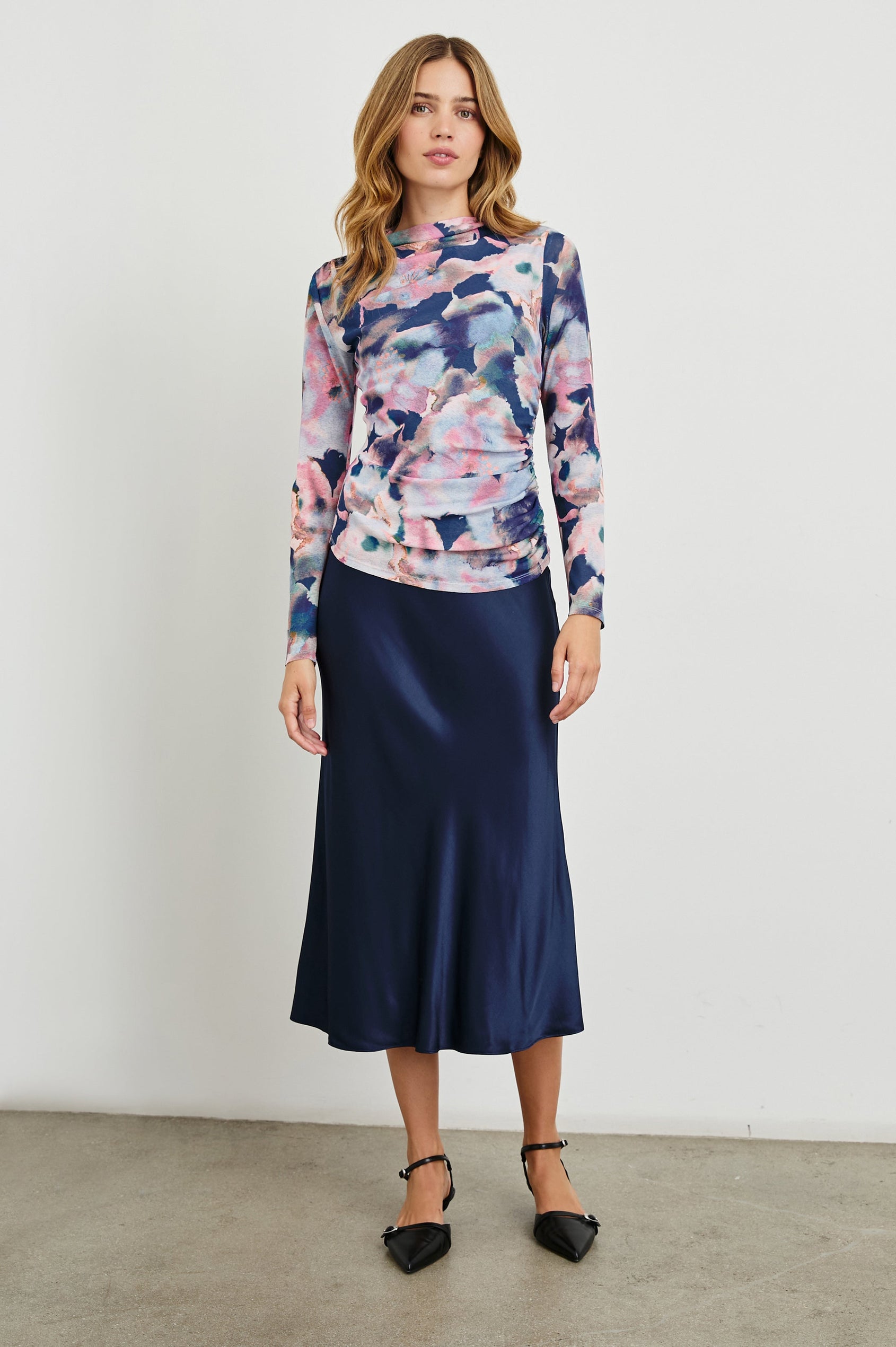 Joelle Long Sleeve Top with An Asymmetrical Mock Neck and Shirring on the Right Shoulder in Midnight Verbena Colorway, with slightly abstract flowers in pinks, purples, blues and oranges on Midnight - Front Full Body View Featured on Model