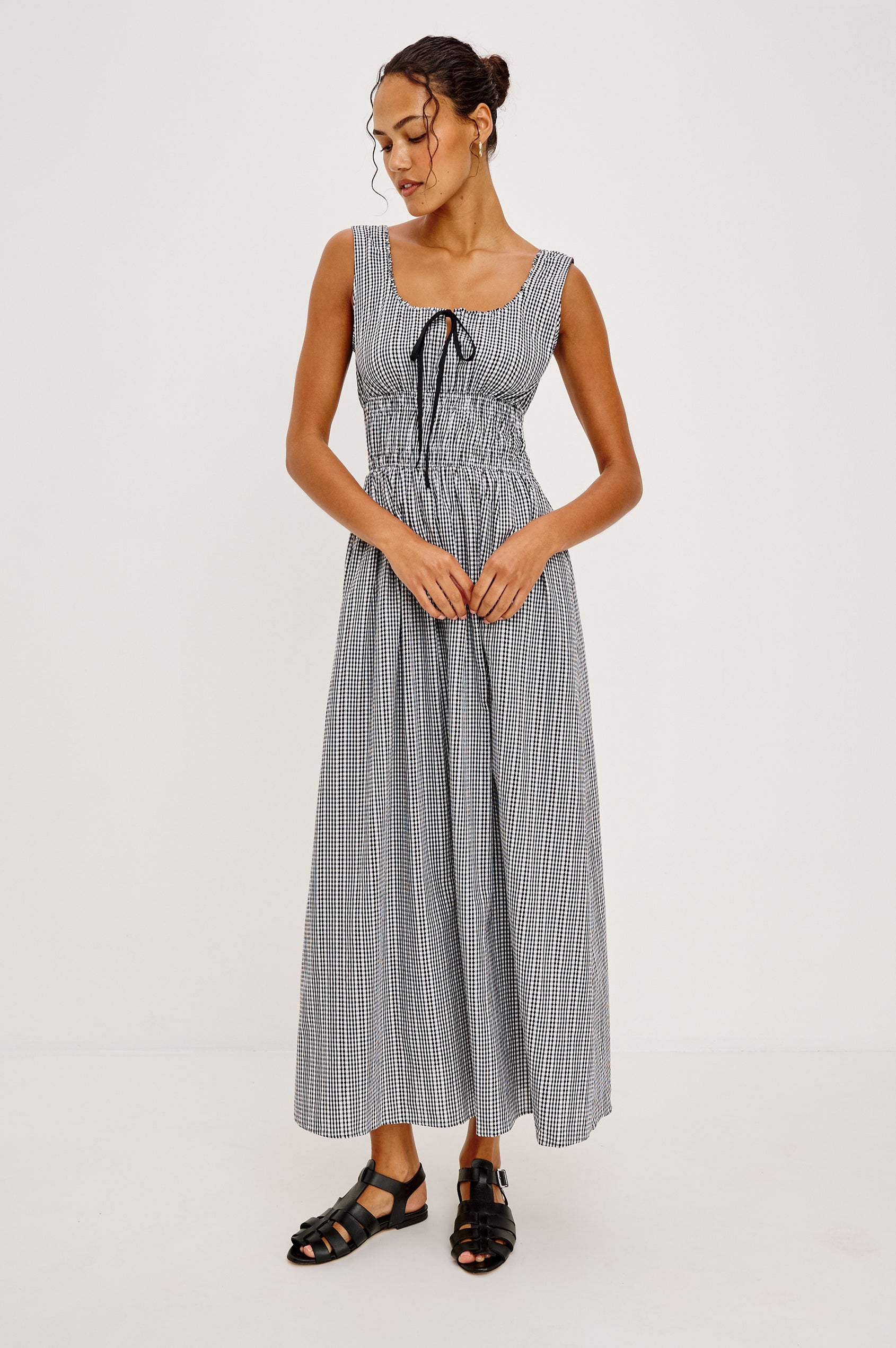 Jordie Maxi Dress in Cotton Poplin With A-Line Silhouette Rounded Square Neckline Rufle Trim Center-Front Bust Cutrout With Self-Ties Smocked Waist Side Pockets and Fully Lined Skirt in Black Gingham Colorway - Full Body Front View Featured on Model